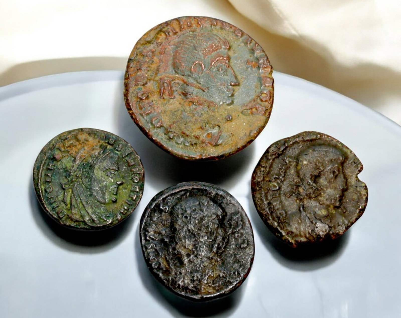 ROMAN EMPIRE: AE Coins - Bronze Coins, 14-21mm, 8.7g (Lot of 4): A collection of four ancient Roman bronze coins, each featuring a distinct imperial portrait on the obverse and various symbolic or military-themed reverses. These coins, essential to Roman commerce a