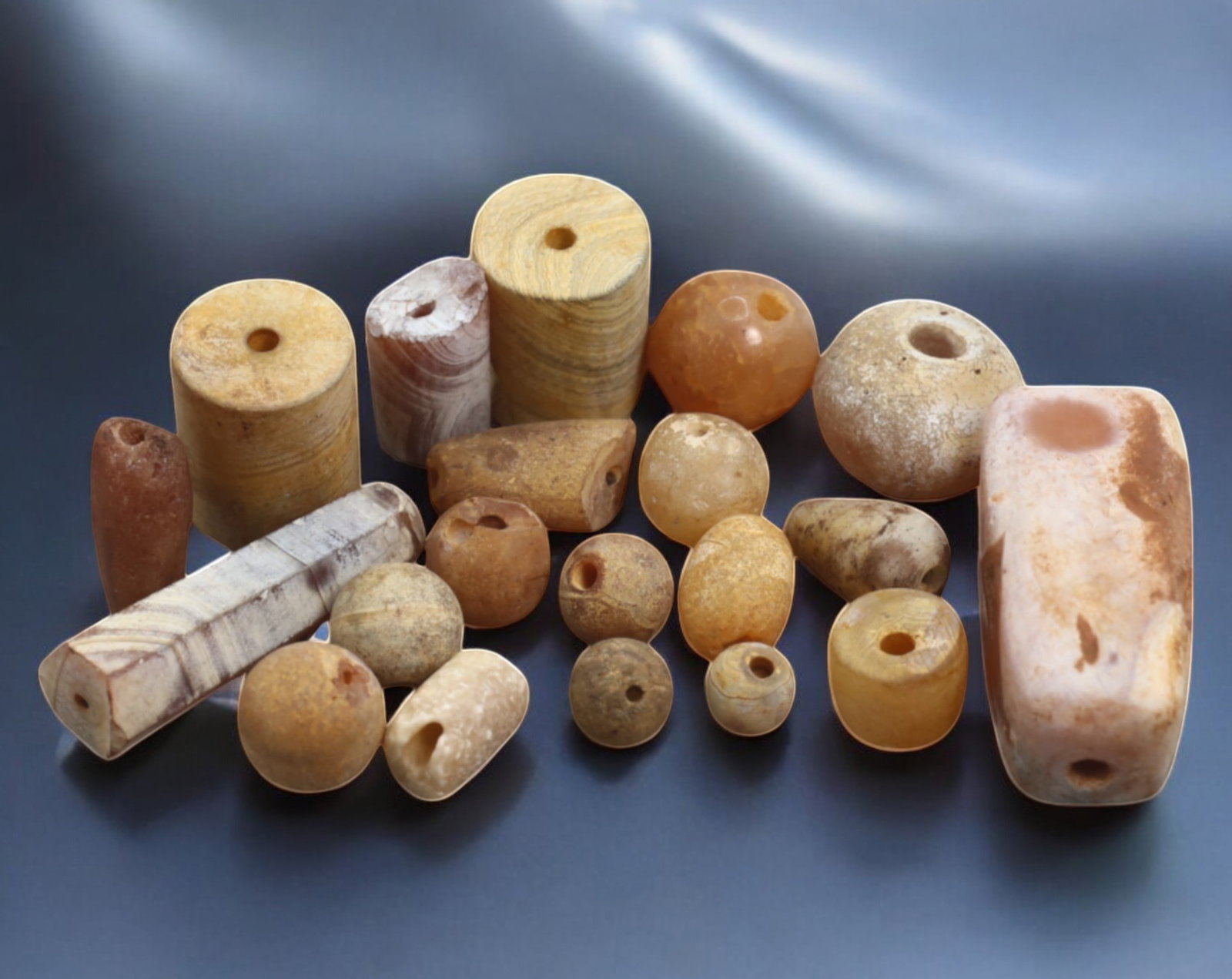 ANCIENT: Agate & Carnelian Beads - 5-30mm, 60g: A remarkable assortment of ancient agate and carnelian beads, meticulously crafted and shaped into spherical, cylindrical, and barrel forms. The beads exhibit a captivating range of warm earthy hues, 