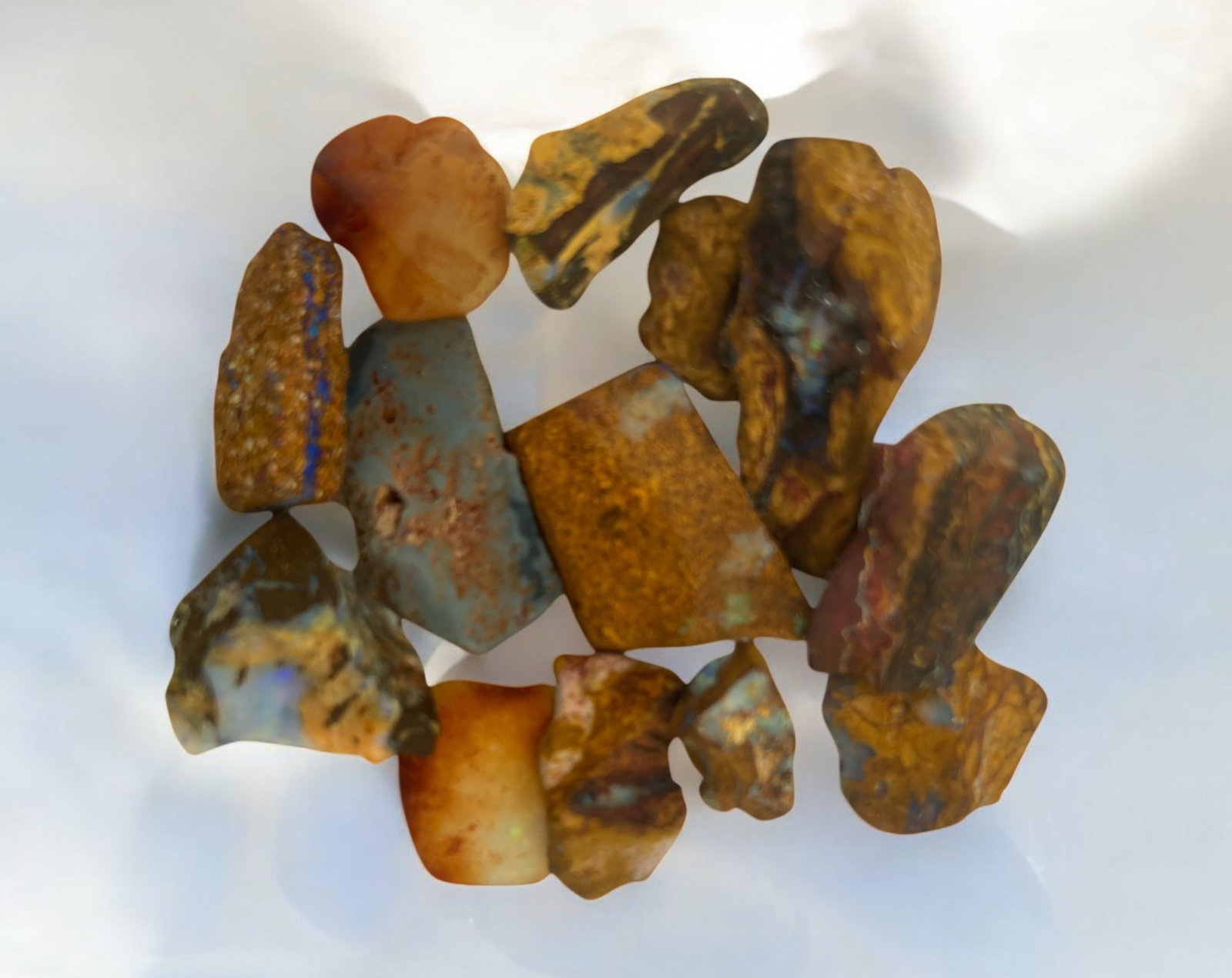 AUSTRALIAN MATRIX BOULDER OPAL - Rough Lot, 14.7g, 9.4-22.7mm Each: A striking lot of natural Australian matrix boulder opal rough. These raw specimens display mesmerizing flashes of blue, green, and gold veins running through ironstone, characteristic of high-quality