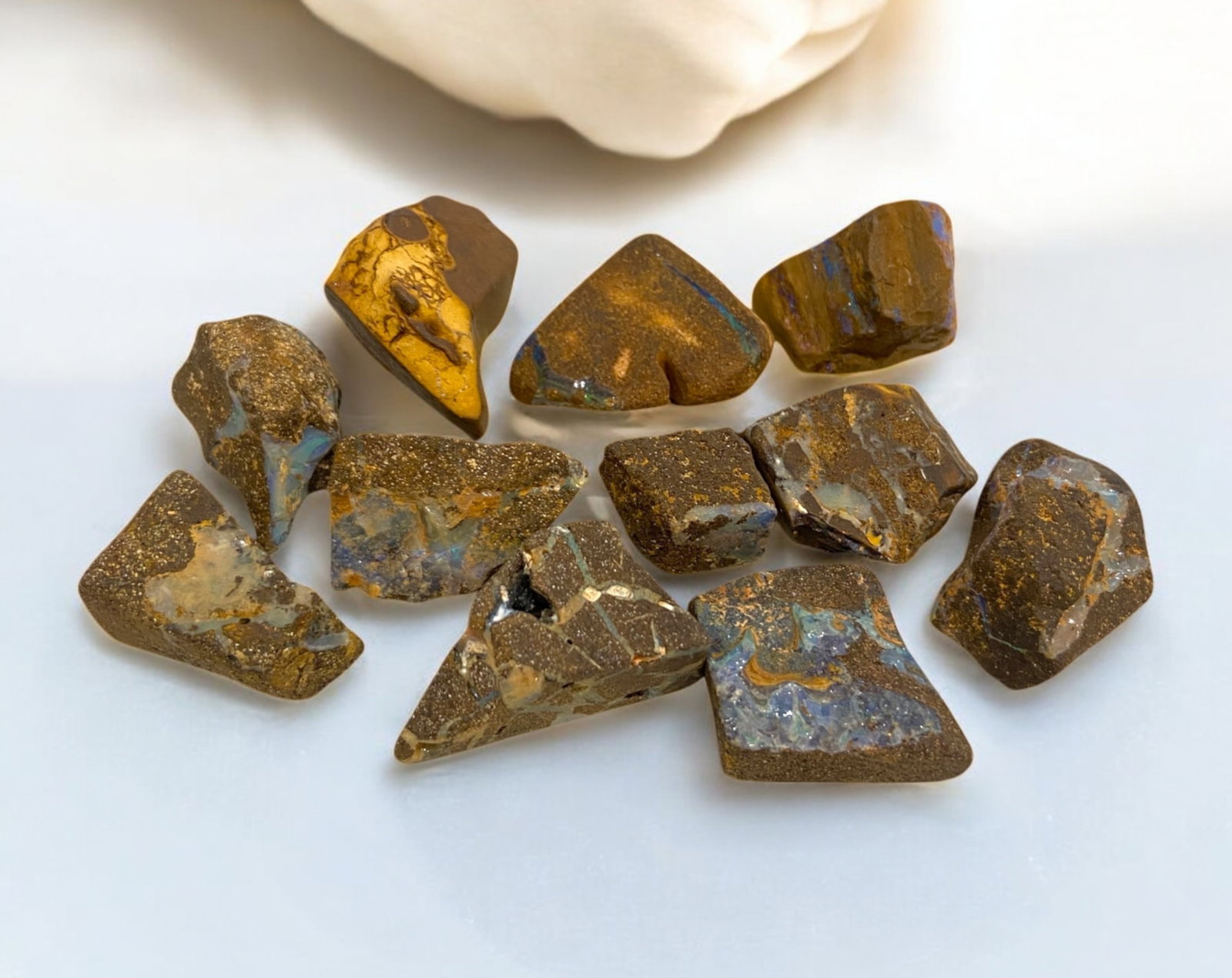 AUSTRALIAN MATRIX BOULDER OPAL - Rough Lot, 60g, 1-3cm Each: A striking lot of natural Australian matrix boulder opal rough, weighing a total of 76g, with individual pieces ranging from 2-3cm in size. These raw specimens display mesmerizing flashes of blue, gre