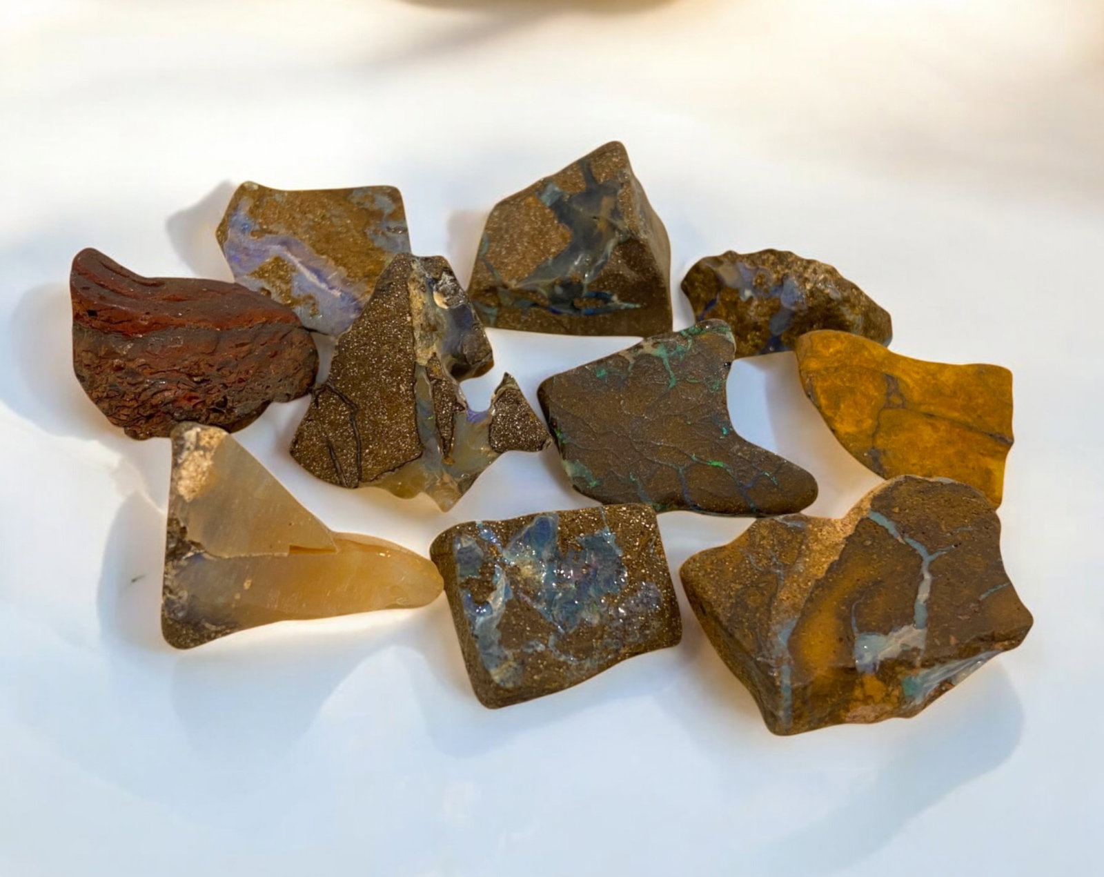 AUSTRALIAN MATRIX BOULDER OPAL - Rough Lot, 43g, 2-2.5cm Each: A striking lot of natural Australian matrix boulder opal rough, weighing a total of 76g, with individual pieces ranging from 2-3cm in size. These raw specimens display mesmerizing flashes of blue, gre