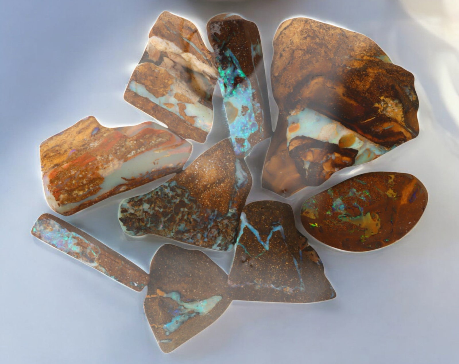 AUSTRALIAN MATRIX BOULDER OPAL - Rough Lot, 43g, 1-3cm (Images Taken Wet): A striking lot of natural Australian matrix boulder opal rough. These raw specimens display mesmerizing flashes of blue, green, and gold veins running through ironstone, characteristic of high-quality
