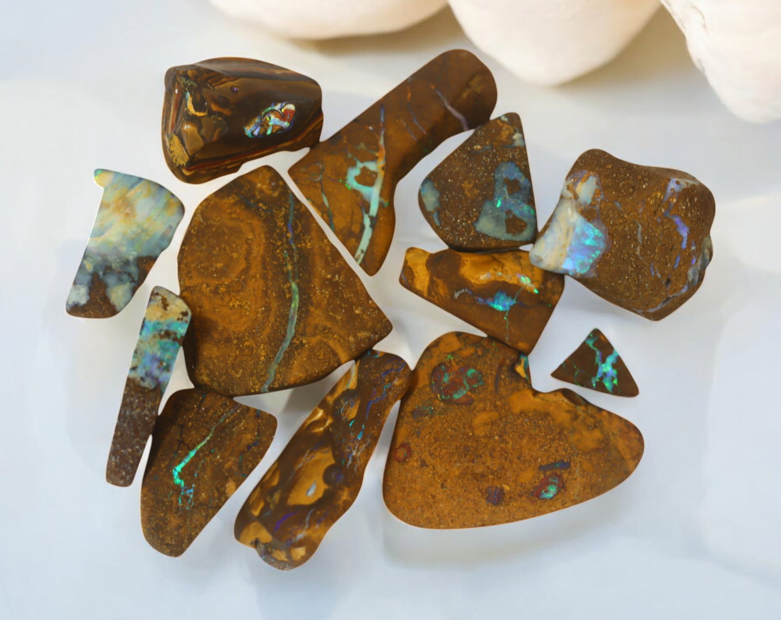 AUSTRALIAN MATRIX BOULDER OPAL - Rough Lot, 42g, 1-3cm (Images Taken Wet): A striking lot of natural Australian matrix boulder opal rough. These raw specimens display mesmerizing flashes of blue, green, and gold veins running through ironstone, characteristic of high-quality