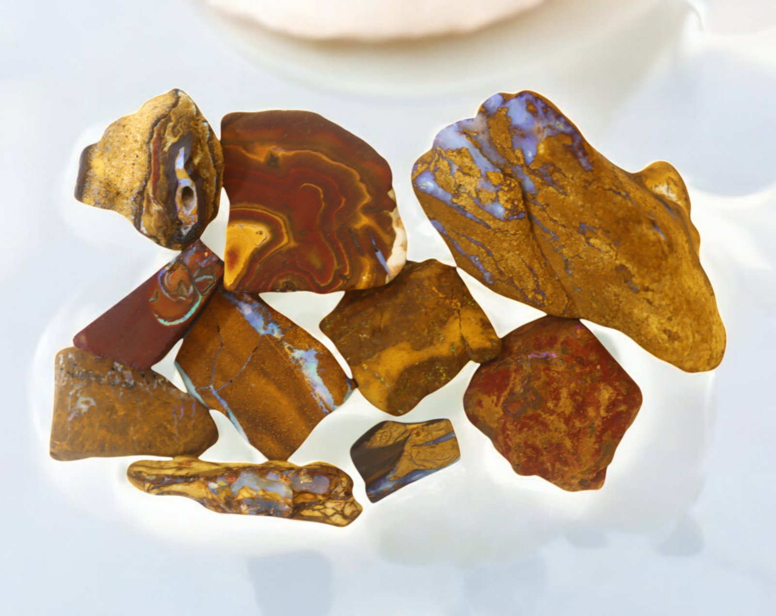 AUSTRALIA: Matrix Boulder Opal Rough Lot, 125g, 1-5.5 cm (Images Taken Wet): Stunning lot of natural Australian matrix boulder opal rough, these specimens showcase a vibrant interplay of opalized veins and swirls embedded in rich ironstone, displaying flashes of electric blues