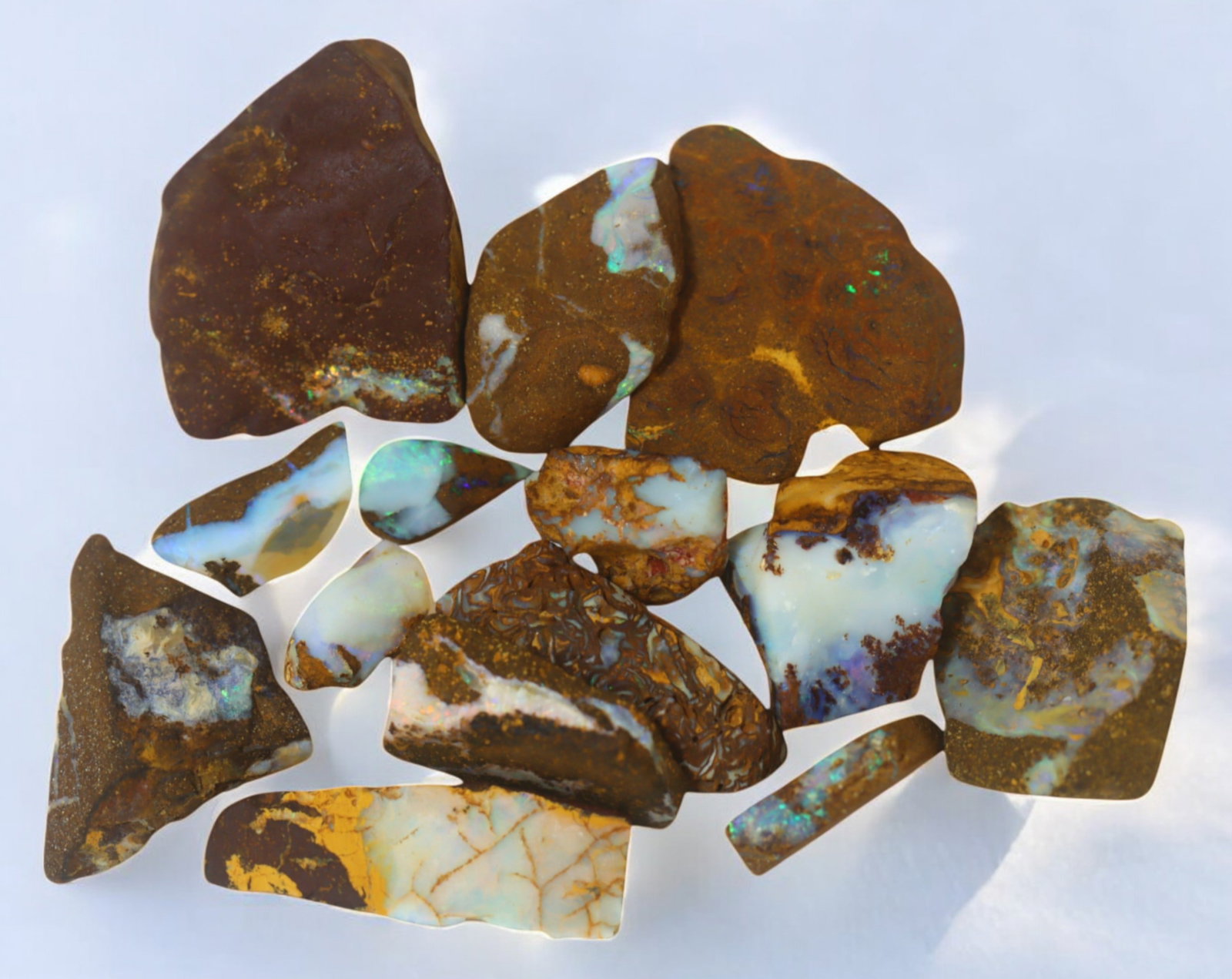 AUSTRALIAN MATRIX BOULDER OPAL - Rough Lot, 36g, 1-3cm (Images Taken Wet): A striking lot of natural Australian matrix boulder opal rough. These raw specimens display mesmerizing flashes of blue, green, and gold veins running through ironstone, characteristic of high-quality