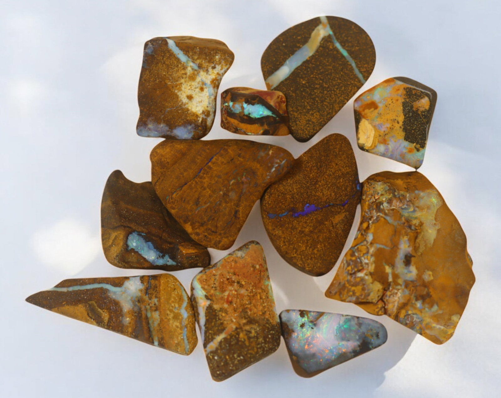 AUSTRALIAN MATRIX BOULDER OPAL - Rough Lot, 37g, 1-3cm (Images Taken Wet): A striking lot of natural Australian matrix boulder opal rough. These raw specimens display mesmerizing flashes of blue, green, and gold veins running through ironstone, characteristic of high-quality