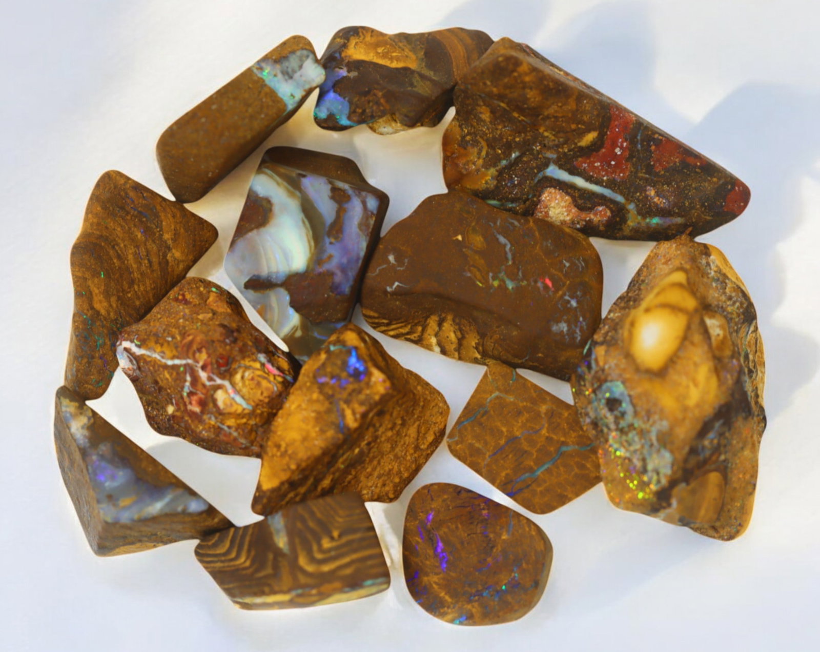 AUSTRALIAN MATRIX BOULDER OPAL - Rough Lot, 55g, 1-3cm (Images Taken Wet): A striking lot of natural Australian matrix boulder opal rough. These raw specimens display mesmerizing flashes of blue, green, and gold veins running through ironstone, characteristic of high-quality