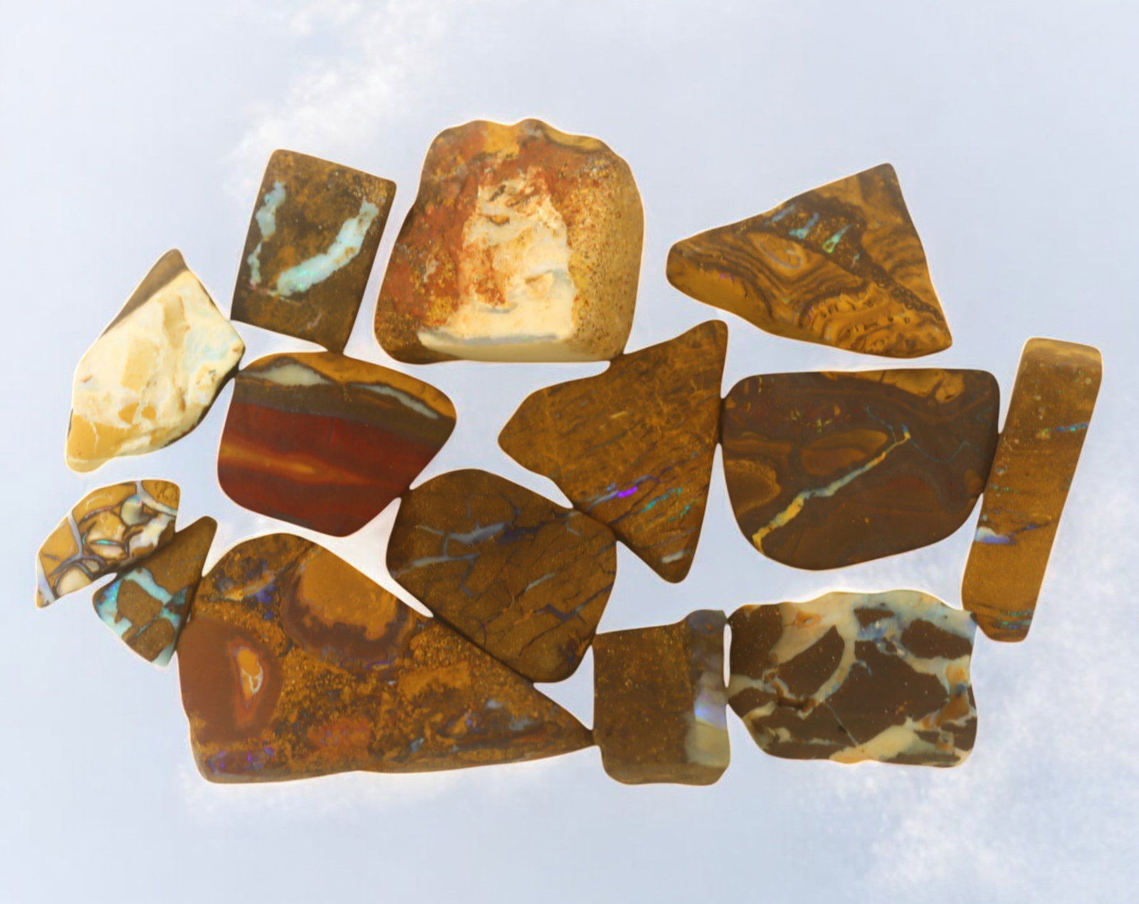 AUSTRALIAN MATRIX BOULDER OPAL - Rough Lot, 51g, 1-3.6cm (Images Taken Wet): A striking lot of natural Australian matrix boulder opal rough. These raw specimens display mesmerizing flashes of blue, green, and gold veins running through ironstone, characteristic of high-quality
