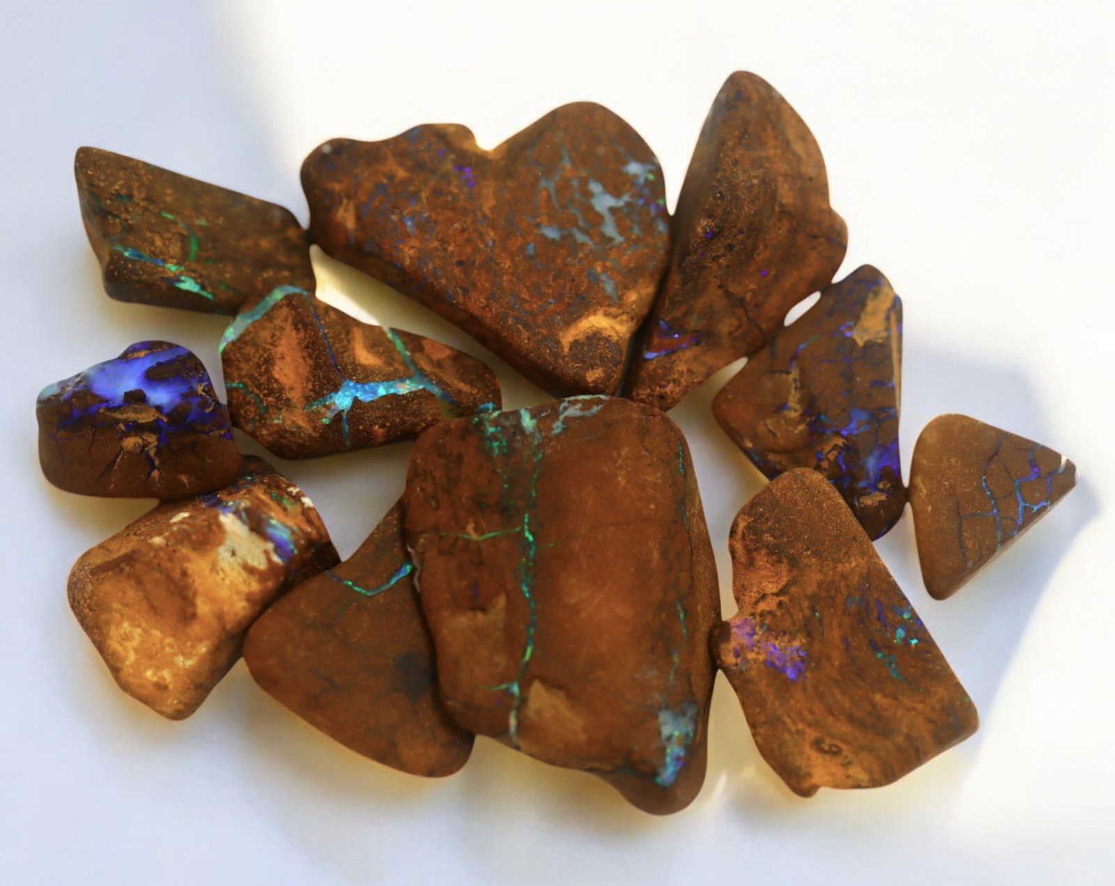AUSTRALIAN MATRIX BOULDER OPAL - Rough Lot, 1-2.5cm, 24g: A striking lot of natural Australian matrix boulder opal rough. These raw specimens display mesmerizing flashes of blue, green, and gold veins running through ironstone, characteristic of high-quality