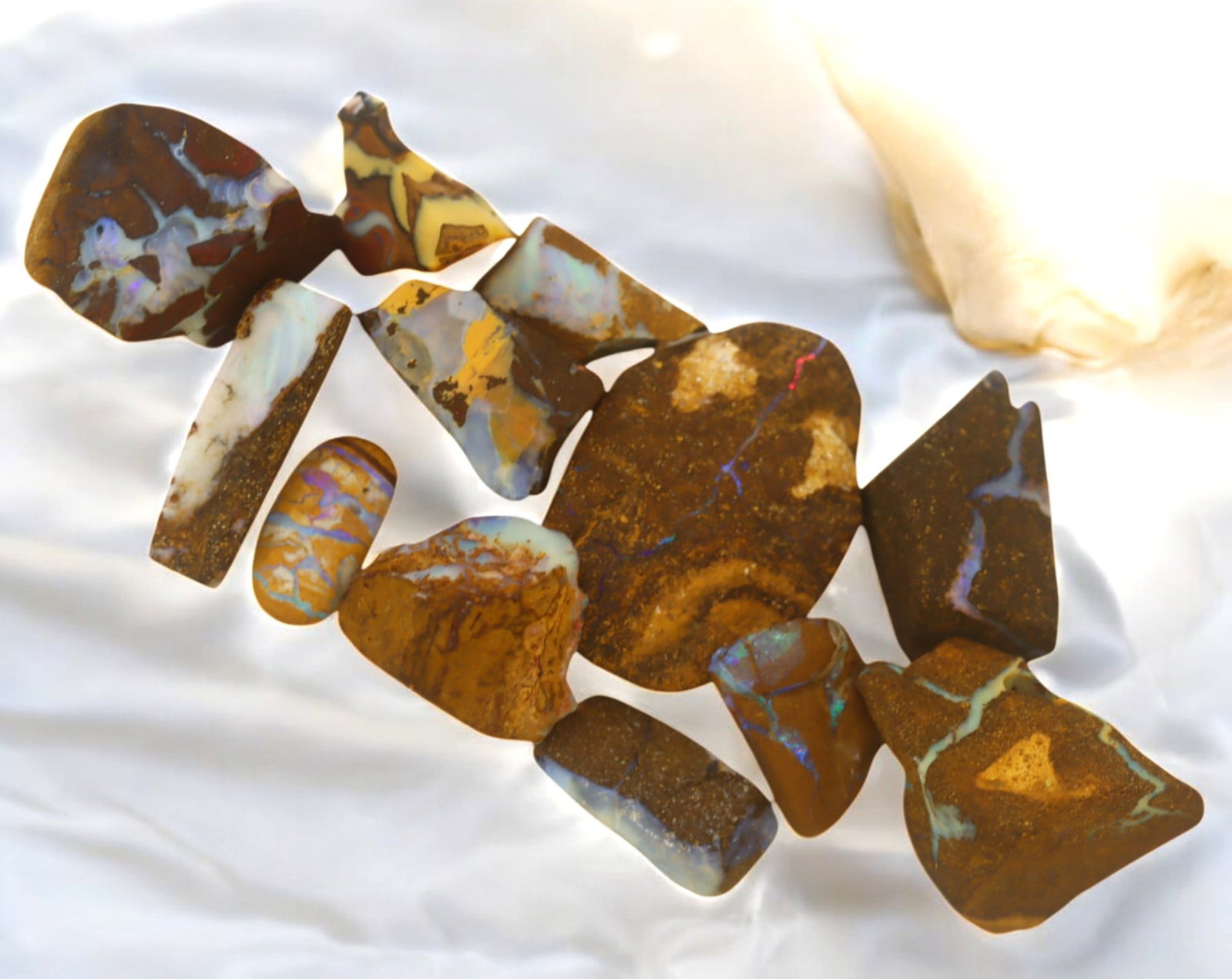 AUSTRALIA: Matrix Boulder Opal Rough Lot, 33g, 1-2.9 cm (Images Taken Wet): Stunning lot of natural Australian matrix boulder opal rough, these specimens showcase a vibrant interplay of opalized veins and swirls embedded in rich ironstone, displaying flashes of electric blues