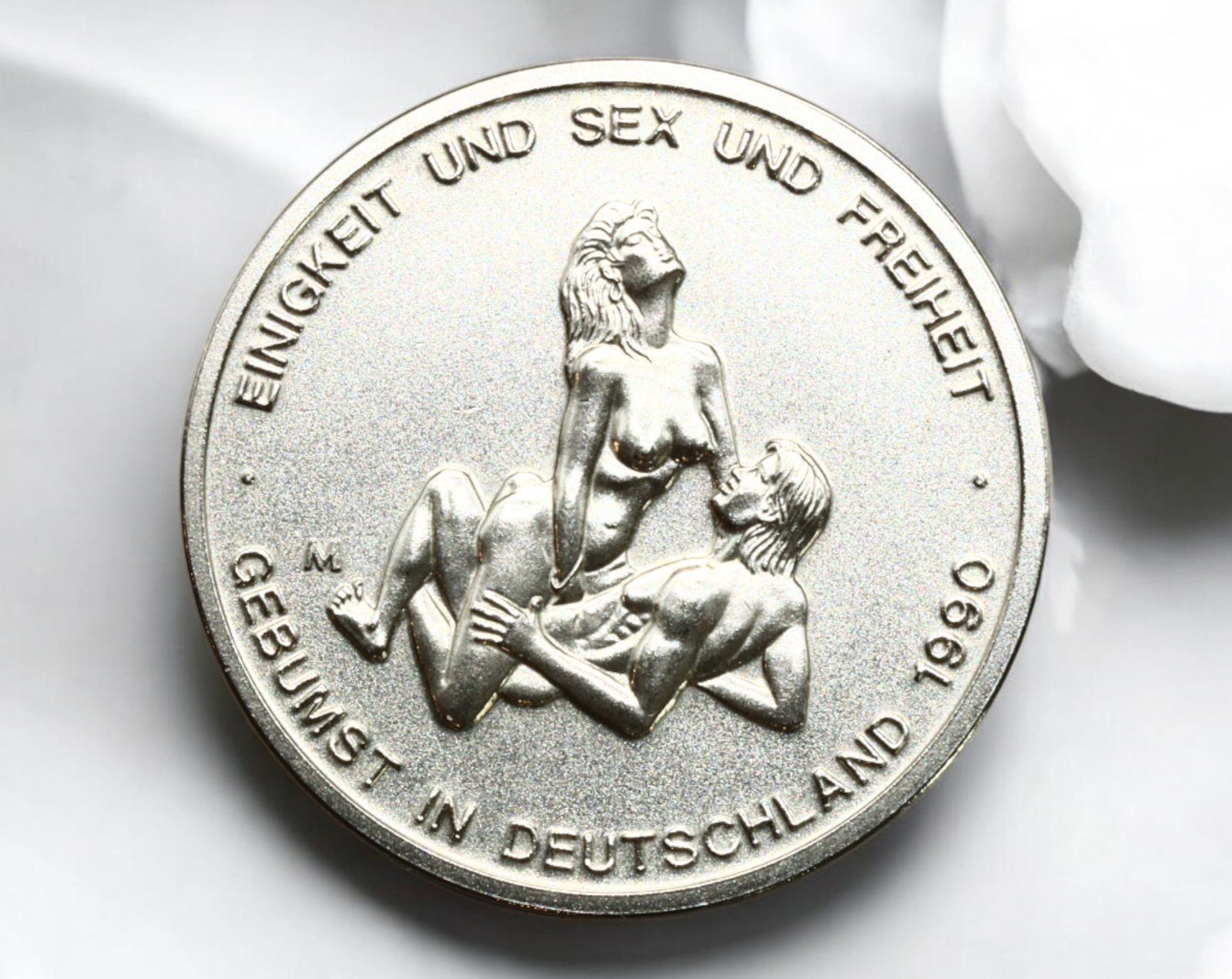 GERMANY: Erotic-Themed Fantasy Token - "Sex Mark," 1990: A provocative and satirical fantasy token, struck in a silver-colored alloy, measuring 31mm in diameter and weighing 13g. The obverse features an explicit erotic scene with the inscription "EINIGKEIT 