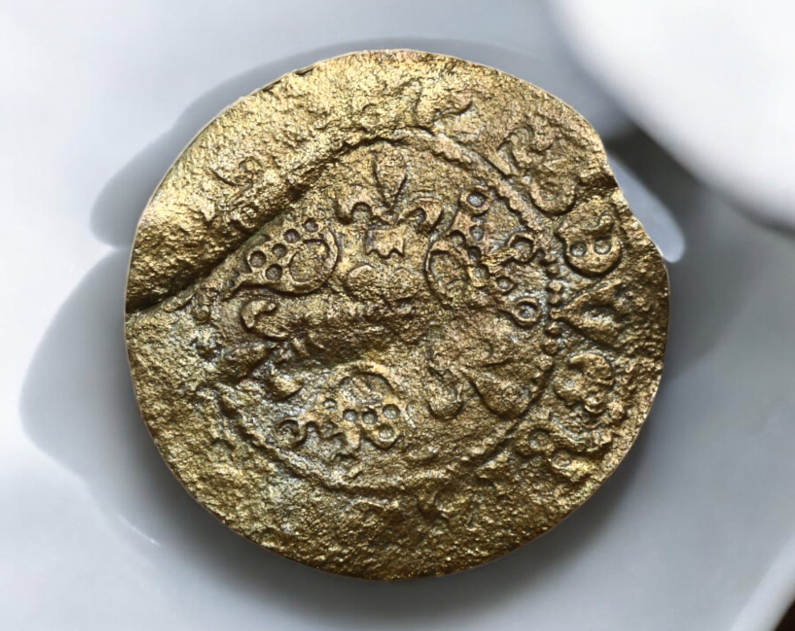 GERMAN STATES: Free Imperial City of Nuremberg - Gilt Brass Jeton, 1586-1635: A rare gilt brass jeton from the Free Imperial City of Nuremberg, dating between 1586-1635. Measuring 2.2 cm in diameter and weighing 0.8g, this intricately designed counter was likely used for commer