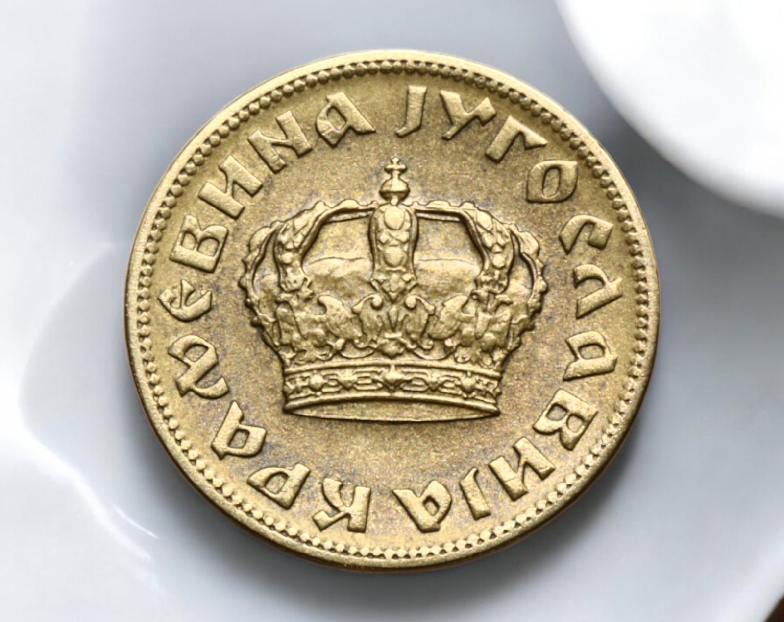 YUGOSLAVIA: Kingdom of Yugoslavia - 1 Dinar Coin, 1938: A well-preserved 1 Dinar coin from the Kingdom of Yugoslavia, minted in 1938. Struck in a copper-nickel alloy, the coin weighs 3.4g and measures 2.1cm in diameter. The obverse showcases the royal crow