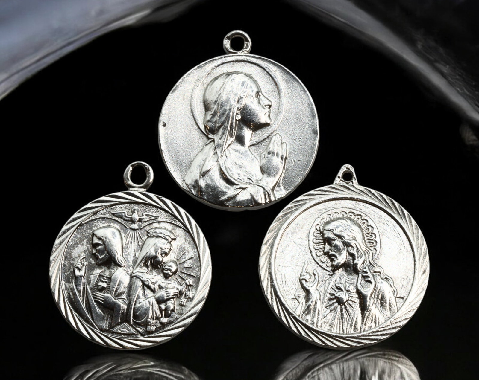 SPAIN: Religious Devotional Medals - Silver, Sacred Heart & Virgin Mary, 20th Century: A collection of three religious devotional medals, struck in silver, each measuring approximately 2.6-2.9 cm in diameter with a total weight of 18.9g. These medals depict sacred Christian iconography,
