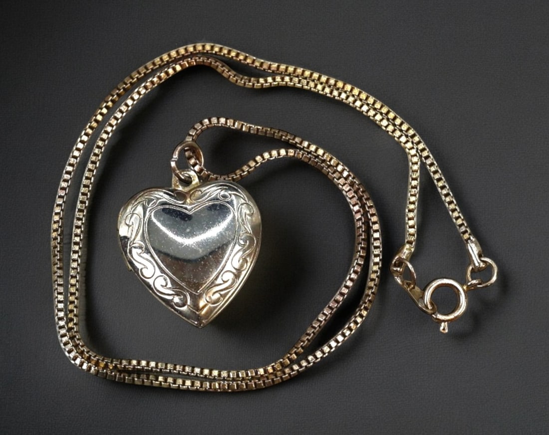 SENTIMENTAL JEWELRY: Necklace - Silver-Tone Heart Locket with Scrollwork, 42.5 cm: Delicately romantic, this heart-shaped locket necklace captures the enduring appeal of sentimental jewelry. The pendant features a smooth domed heart framed by softly swirling scrollwork, suspended fr
