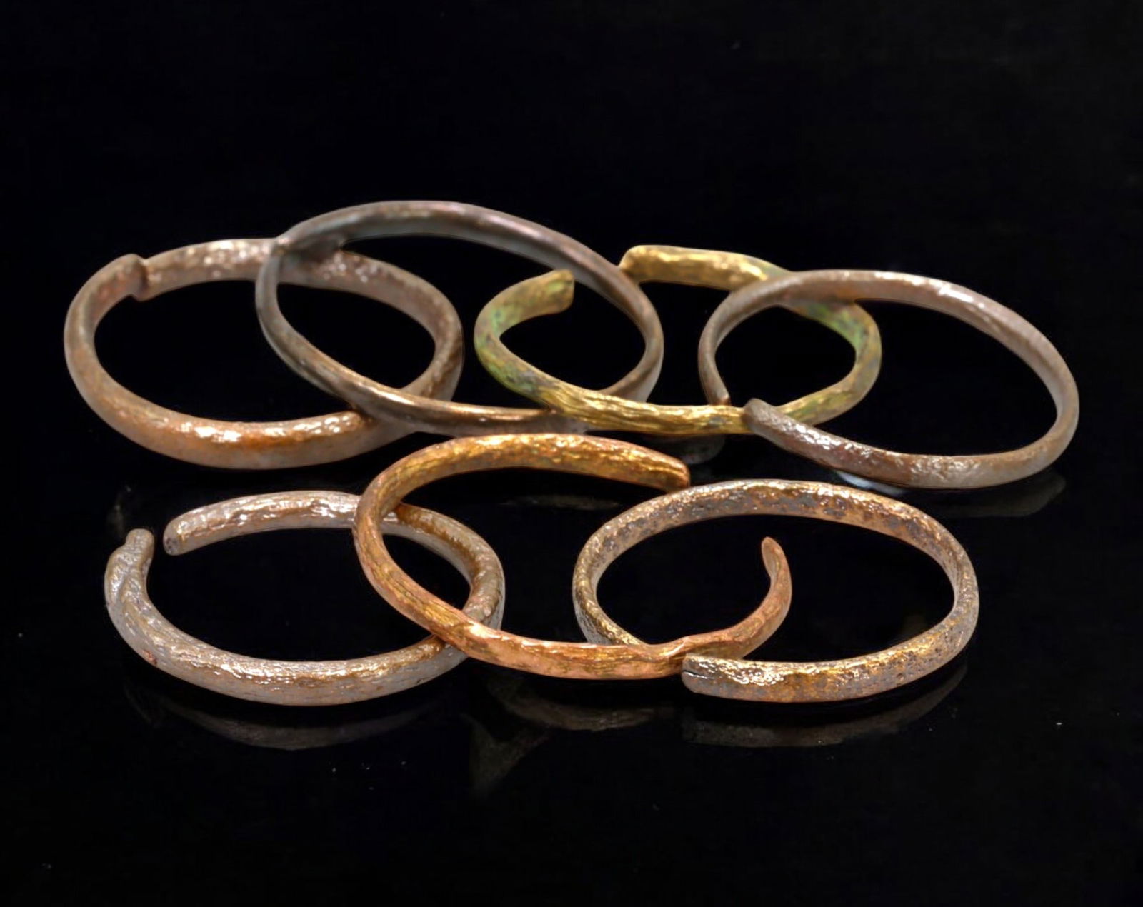 VIKING AGE: Lot of Bronze & Brass Engagement or Wedding Rings - 9th-11th Century: A captivating set of Viking-era engagement or wedding rings, crafted in bronze and brass. These finely shaped rings exhibit a rich patina, with some featuring smooth, polished surfaces while others re