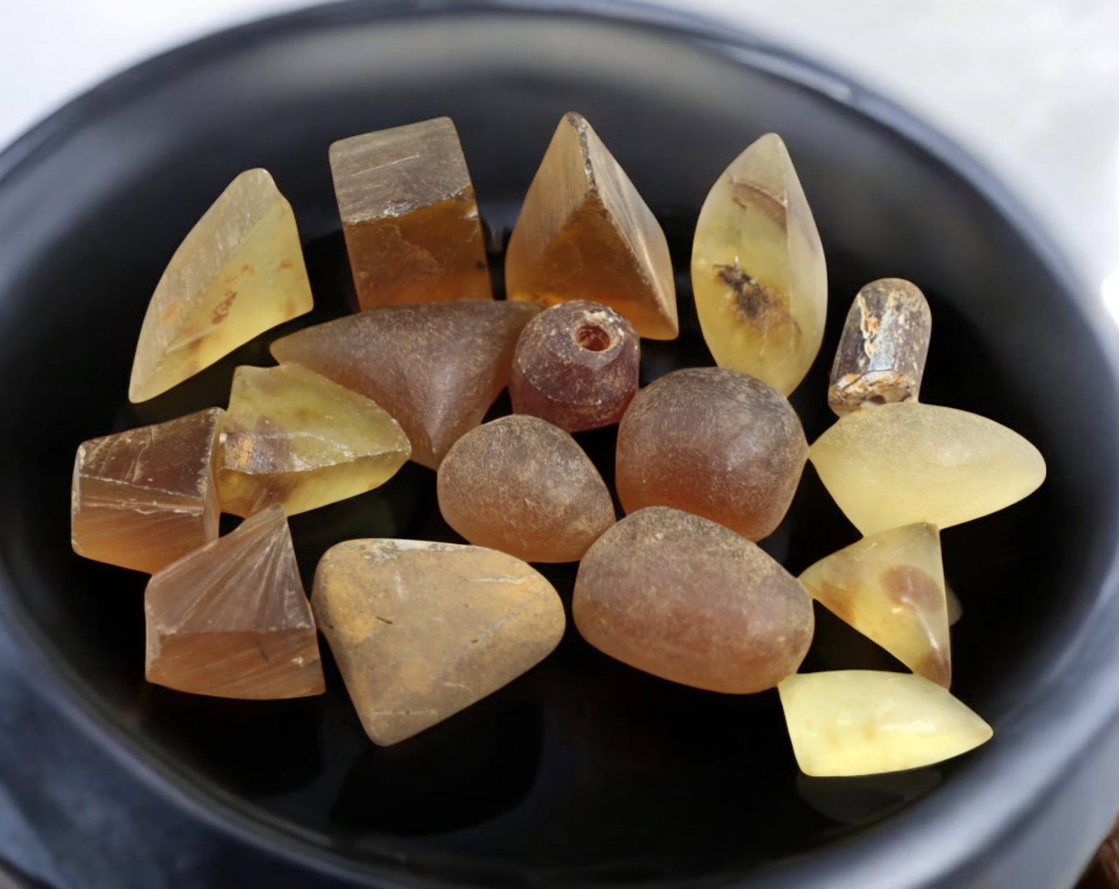 BALTIC: Preform Rough Amber Cabochon Lot - 23g, 1-2.5cm, Baltic Natural: A collection of preformed rough amber cabochons, totaling 23g and ranging from 1cm to 2.5cm in size. These semi-shaped pieces exhibit golden-brown, honey, and translucent yellow hues, with some showin
