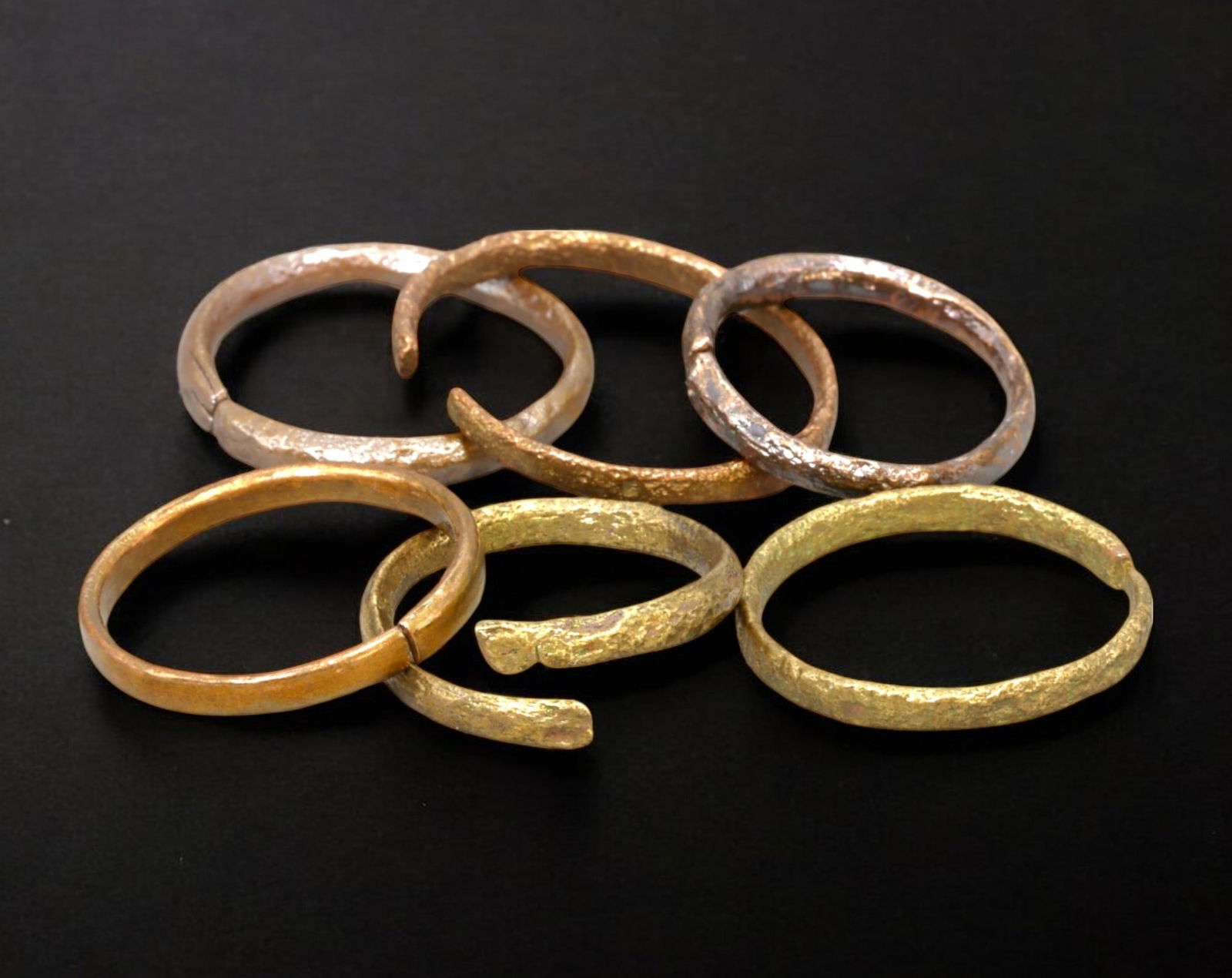 VIKING AGE: Lot of Bronze & Brass Engagement or Wedding Rings - 9th-11th Century: A captivating set of Viking-era engagement or wedding rings, crafted in bronze and brass. These finely shaped rings exhibit a rich patina, with some featuring smooth, polished surfaces while others re