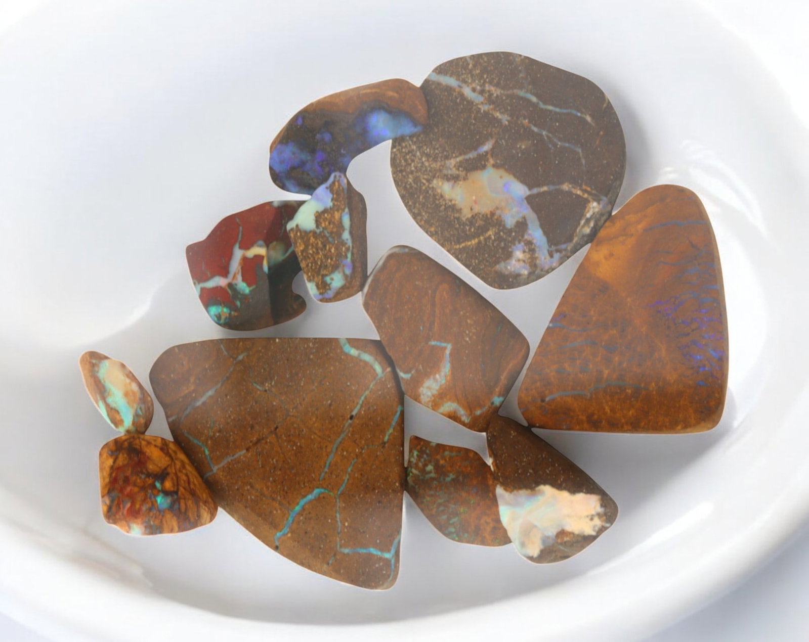 AUSTRALIAN MATRIX BOULDER OPAL - Rough Lot, 42g, 1-3.5cm (Images Taken Wet): A striking lot of natural Australian matrix boulder opal rough. These raw specimens display mesmerizing flashes of blue, green, and gold veins running through ironstone, characteristic of high-quality