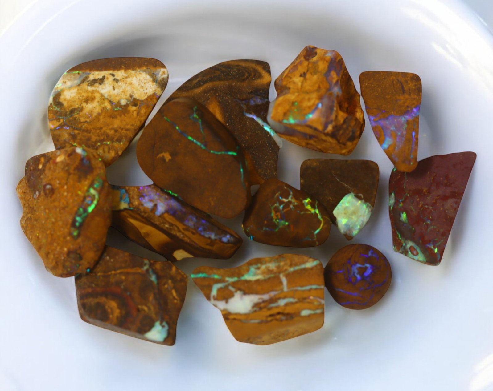 AUSTRALIAN MATRIX BOULDER OPAL - Rough Lot, 27g, 1-2.3cm (Images Taken Wet): A striking lot of natural Australian matrix boulder opal rough. These raw specimens display mesmerizing flashes of blue, green, and gold veins running through ironstone, characteristic of high-quality
