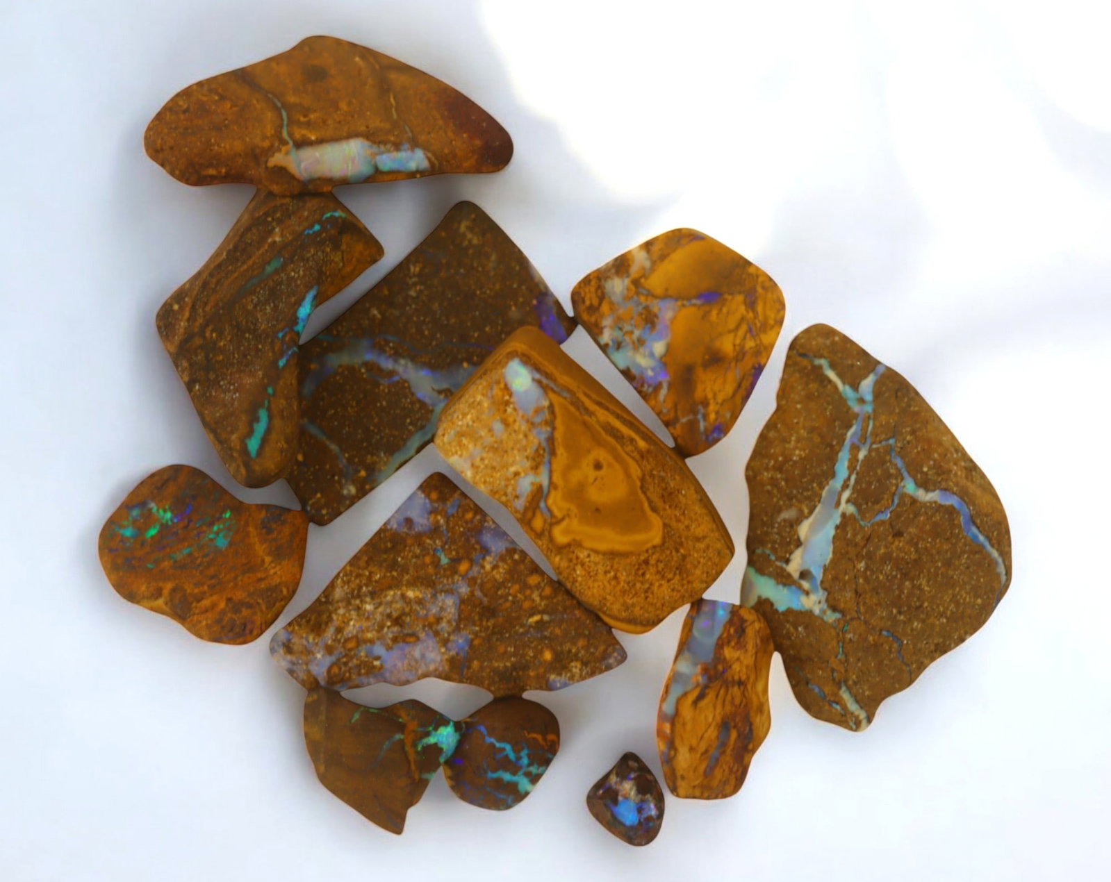 AUSTRALIA: Matrix Boulder Opal Rough Lot, 27g, 0.6-3cm (Images Taken Wet): Stunning lot of natural Australian matrix boulder opal rough, these specimens showcase a vibrant interplay of opalized veins and swirls embedded in rich ironstone, displaying flashes of electric blues