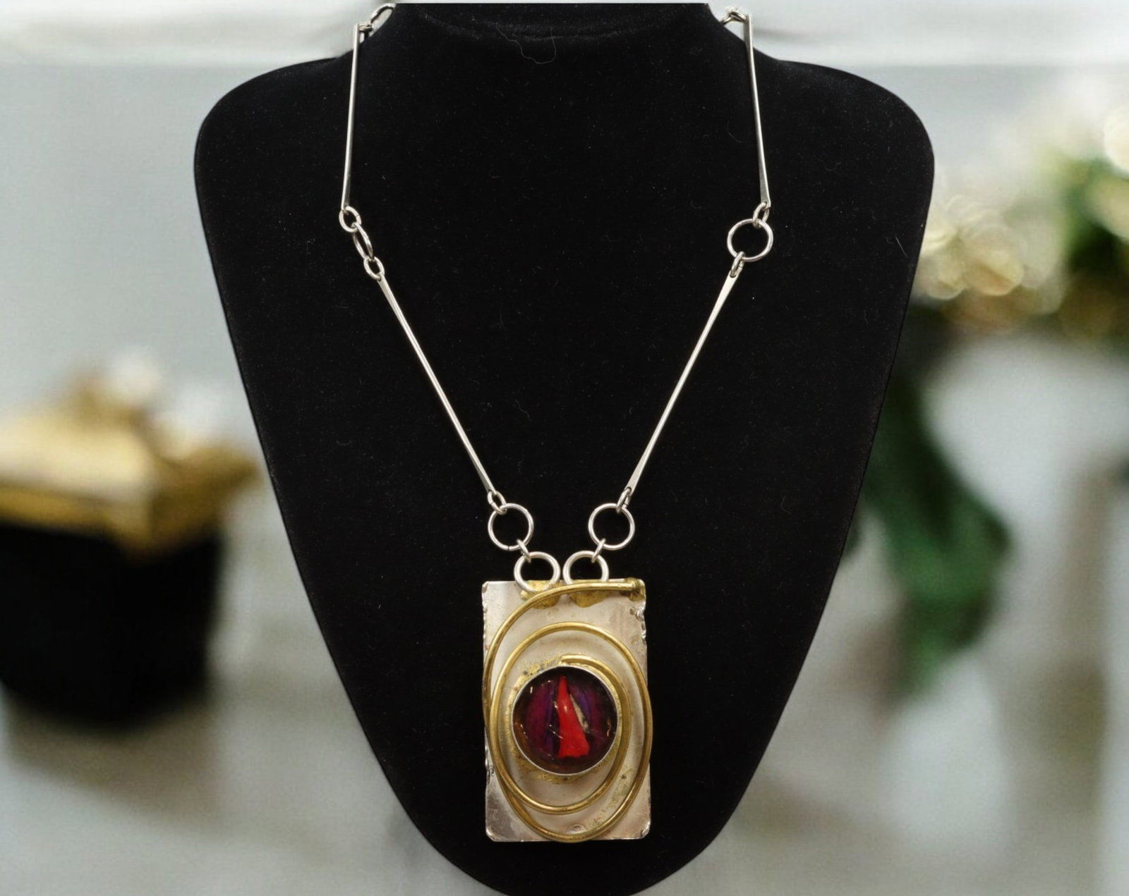 MID-CENTURY MODERNIST: Necklace - Silver & Brass with Red Resin Inset, Signed Latappy, ca. 1960s: Bold and architectonic in form, this 70 cm Modernist necklace showcases a rectangular silver pendant set with a domed red resin cabochon, encircled by concentric brass wire detailing. Weighing 86 gram