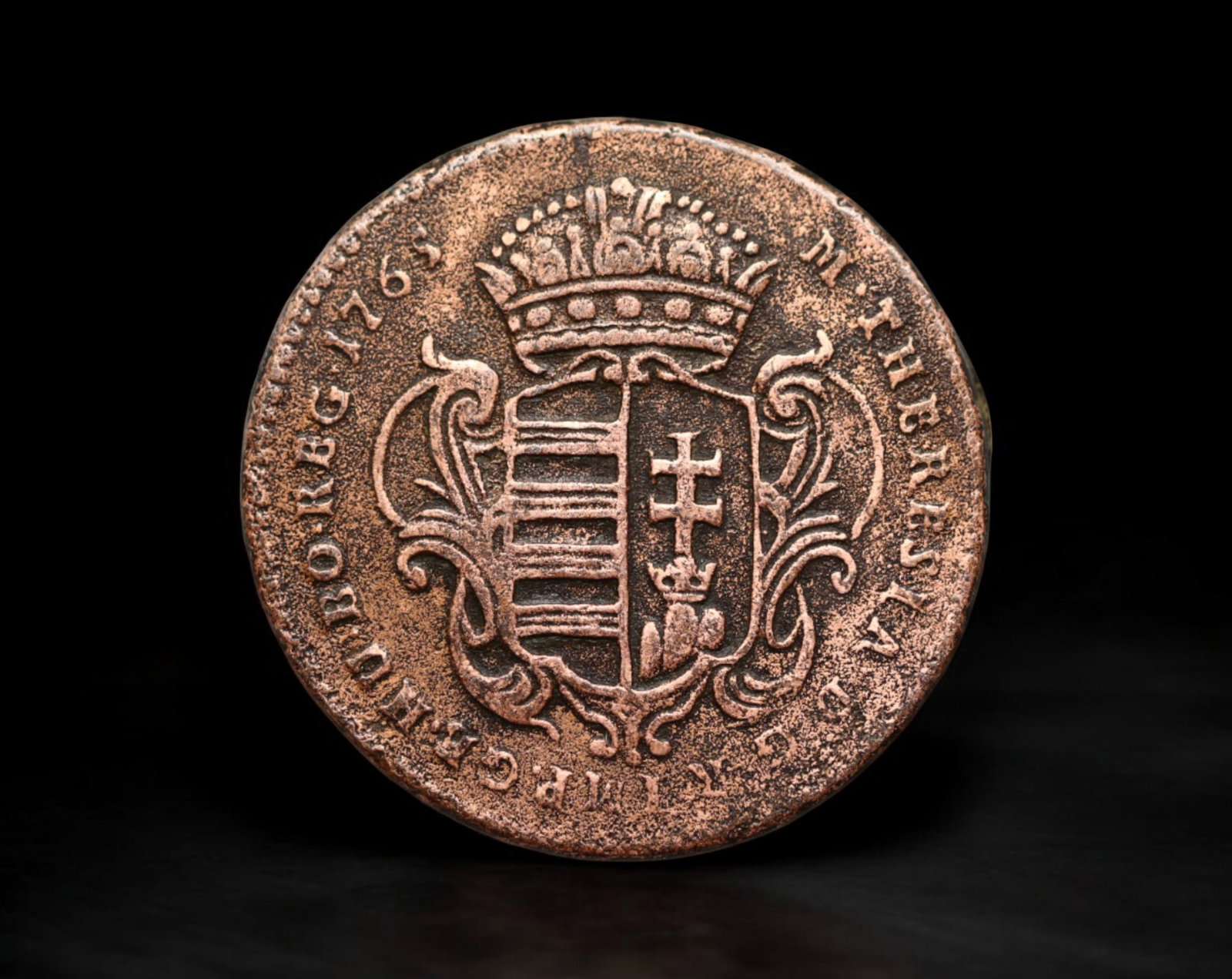 HUNGARY: Maria Theresia - Copper Denar Coin, 1765: A well-preserved 1765 denar issued under Empress Maria Theresia, showcasing Hungary's strong Catholic heritage. The obverse features the crowned Hungarian arms, a symbol of the Habsburg Monarchy's dom