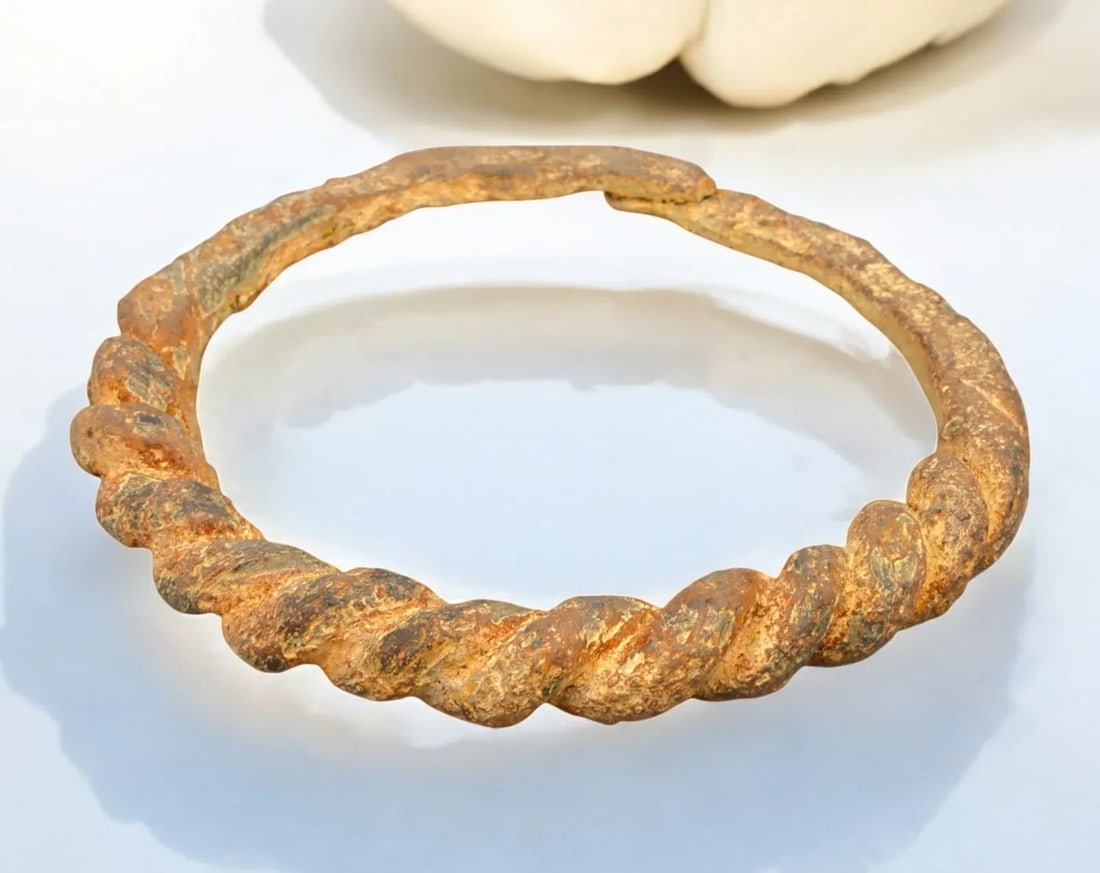 ANCIENT EUROPE: Twisted Bronze Torc Bracelet - Celtic, c. 5th-2nd Century BCE: A substantial ancient Celtic bronze torc bracelet, measuring 11 cm in diameter and weighing 184g, featuring a distinctive twisted design indicative of expert metalworking. The torc's robust form and w