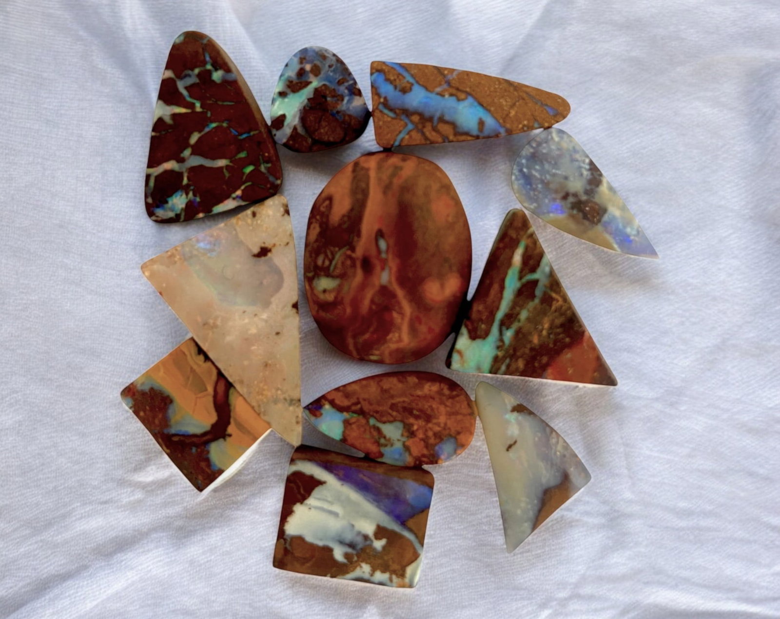 AUSTRALIAN MATRIX BOULDER OPAL - Preform Rough Lot, 11 Pieces, 16.5g, 9-19.5mm (Images Taken Wet): A dazzling lot of preform Australian matrix boulder opals, with individual sizes. These opals have been rubbed and pre-shaped, highlighting their vibrant natural colors and intricate ironstone matrix 