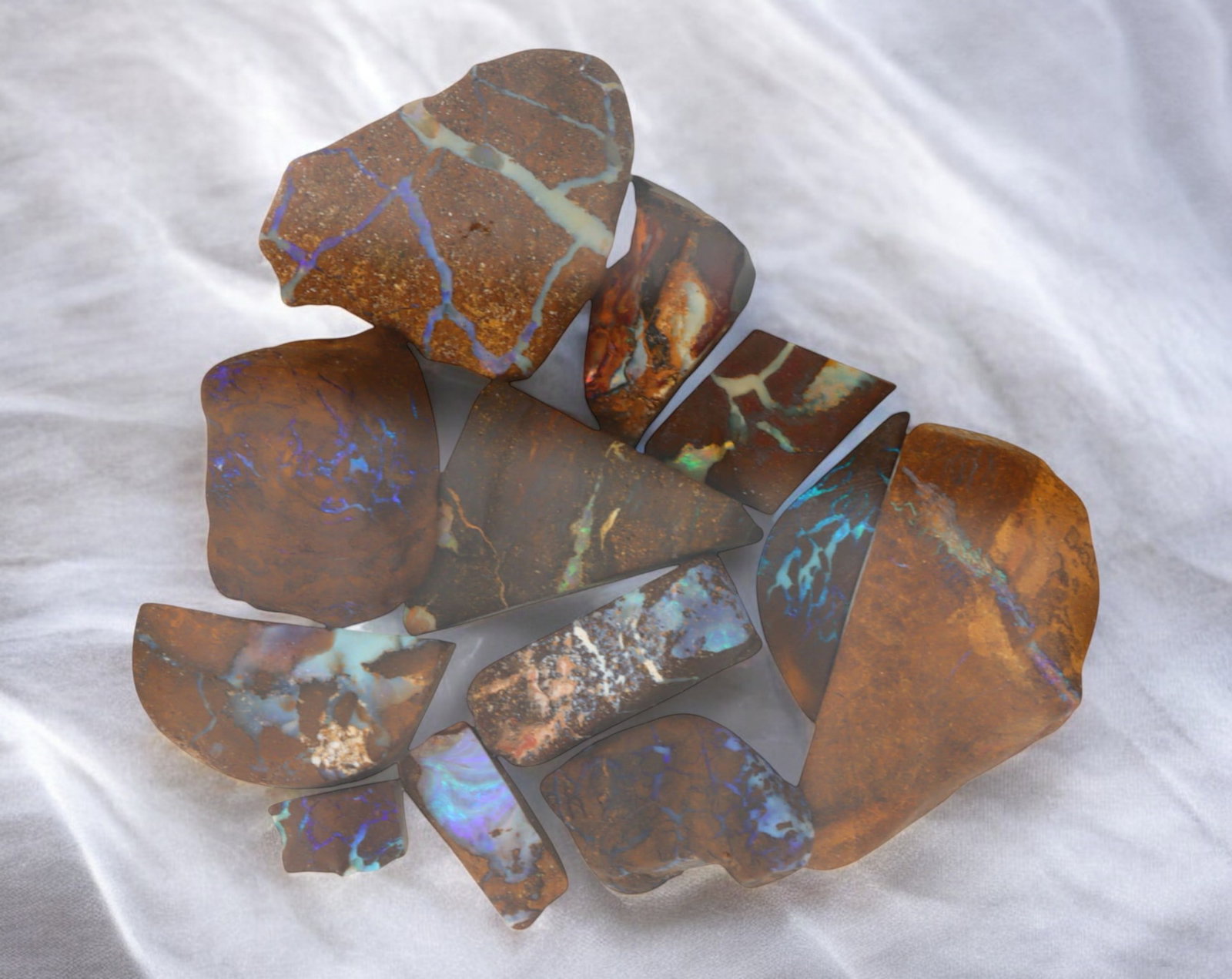 AUSTRALIAN MATRIX BOULDER OPAL - Rough Lot, 44g, 1-3.55cm (Images Taken Wet): A striking lot of natural Australian matrix boulder opal rough. These raw specimens display mesmerizing flashes of blue, green, and gold veins running through ironstone, characteristic of high-quality