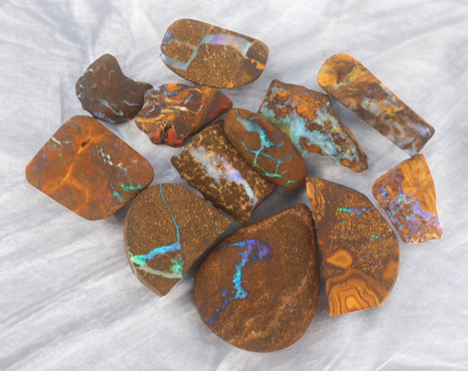 AUSTRALIAN MATRIX BOULDER OPAL - Rough Lot, 36g, 1-3cm (Images Taken Wet): A striking lot of natural Australian matrix boulder opal rough. These raw specimens display mesmerizing flashes of blue, green, and gold veins running through ironstone, characteristic of high-quality