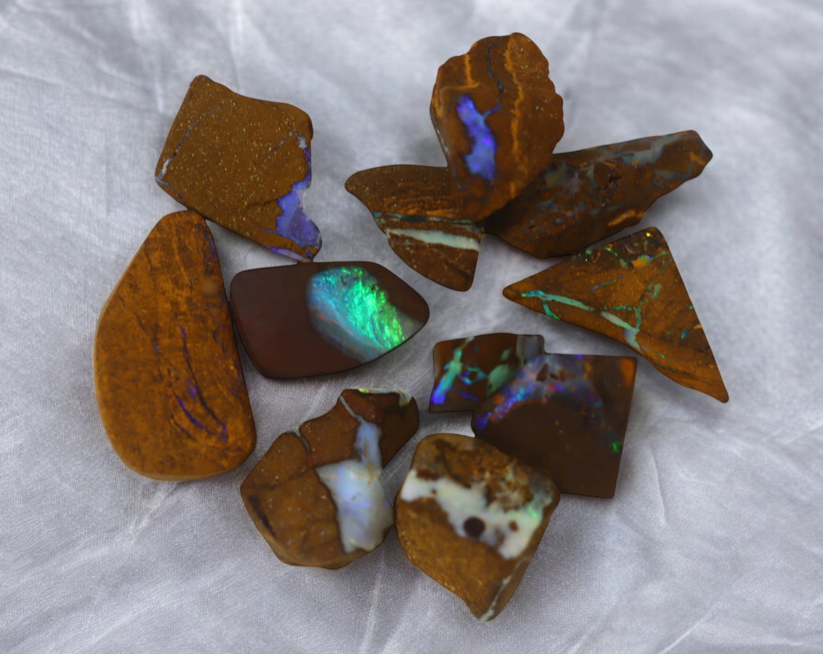 AUSTRALIAN MATRIX BOULDER OPAL - Rough Lot, 27g, 1-2.3cm (Images Taken Wet): A striking lot of natural Australian matrix boulder opal rough. These raw specimens display mesmerizing flashes of blue, green, and gold veins running through ironstone, characteristic of high-quality