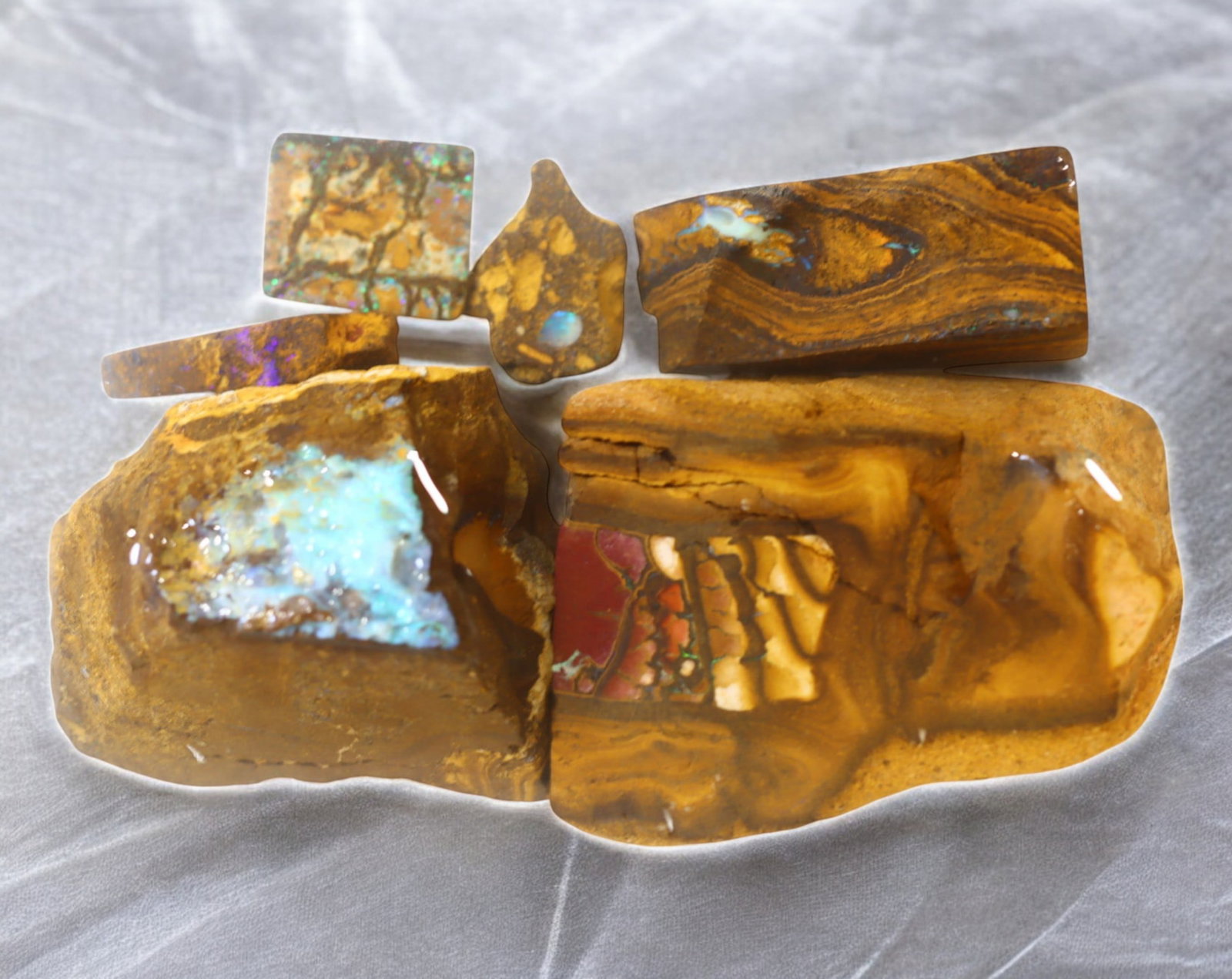 AUSTRALIA: Matrix Boulder Opal Rough Lot, 224g, 1-5.5 cm (Images Taken Wet): Stunning lot of natural Australian matrix boulder opal rough, these specimens showcase a vibrant interplay of opalized veins and swirls embedded in rich ironstone, displaying flashes of electric blues
