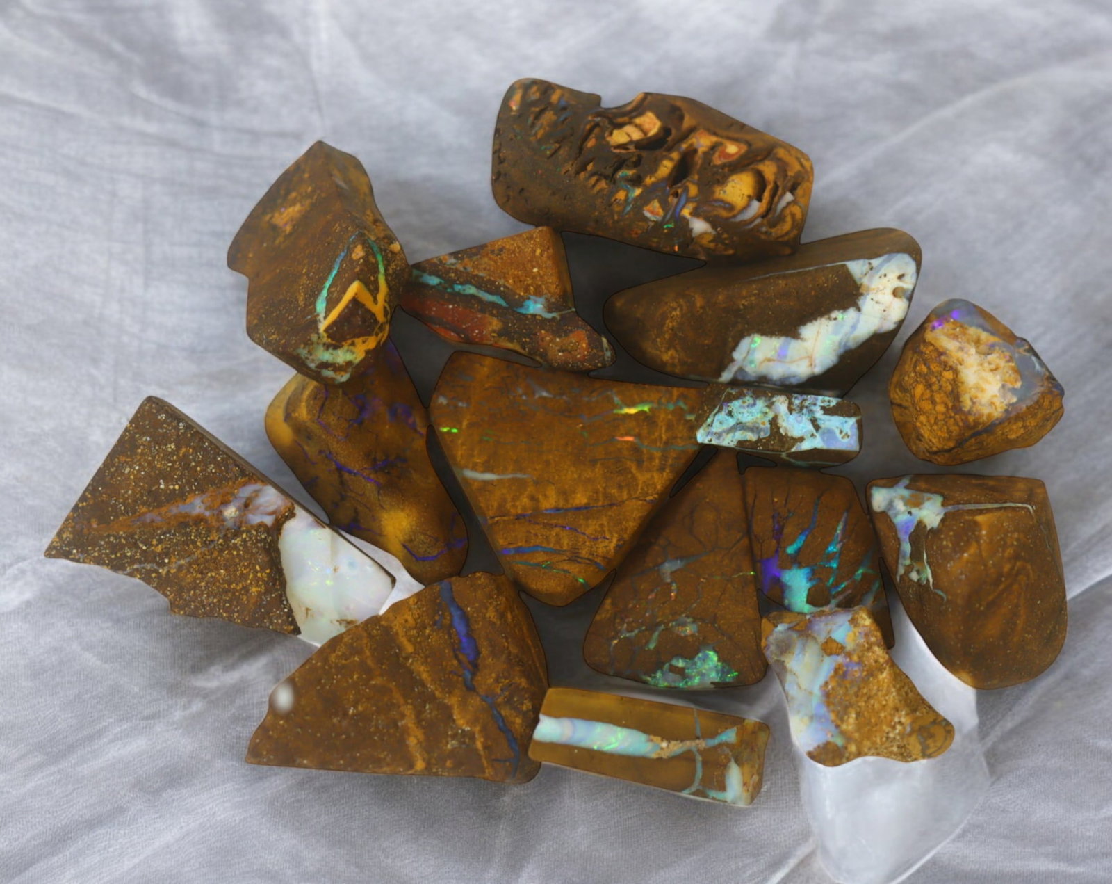 AUSTRALIAN MATRIX BOULDER OPAL - Rough Lot, 34g, 1-2.2cm (Images Taken Wet): A striking lot of natural Australian matrix boulder opal rough. These raw specimens display mesmerizing flashes of blue, green, and gold veins running through ironstone, characteristic of high-quality