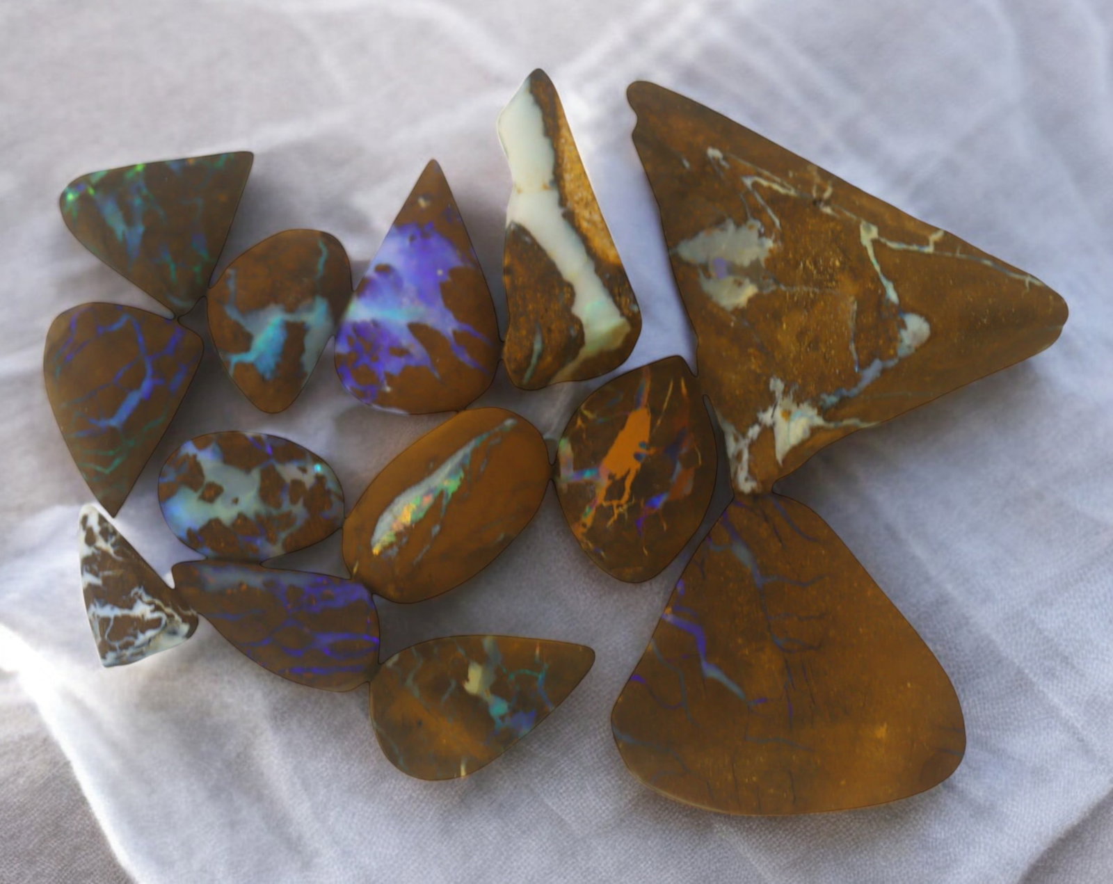 AUSTRALIAN MATRIX BOULDER OPAL - Rough Lot, 15g, 1-2.8cm (Images Taken Wet): A striking lot of natural Australian matrix boulder opal rough. These raw specimens display mesmerizing flashes of blue, green, and gold veins running through ironstone, characteristic of high-quality