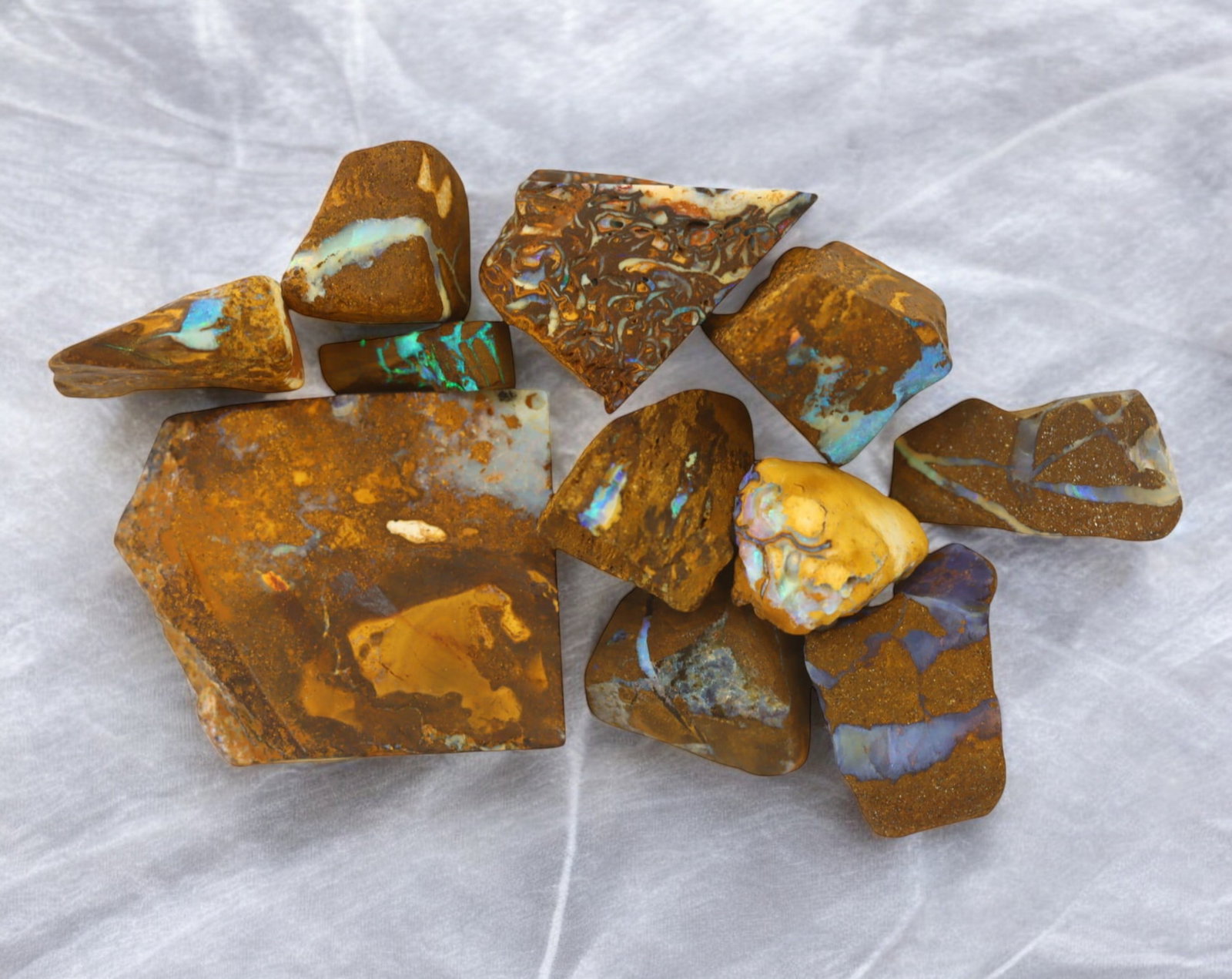 AUSTRALIA: Matrix Boulder Opal Rough Lot, 52g, 1-3.4 cm (Images Taken Wet): Stunning lot of natural Australian matrix boulder opal rough, these specimens showcase a vibrant interplay of opalized veins and swirls embedded in rich ironstone, displaying flashes of electric blues
