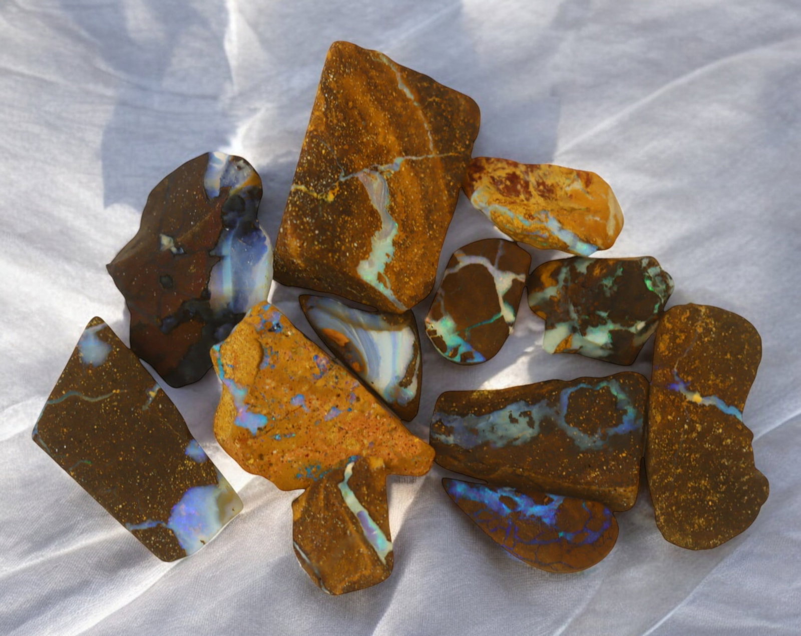 AUSTRALIA: Matrix Boulder Opal Rough Lot, 25g, 1-2.2 cm (Images Taken Wet): Stunning lot of natural Australian matrix boulder opal rough, these specimens showcase a vibrant interplay of opalized veins and swirls embedded in rich ironstone, displaying flashes of electric blues