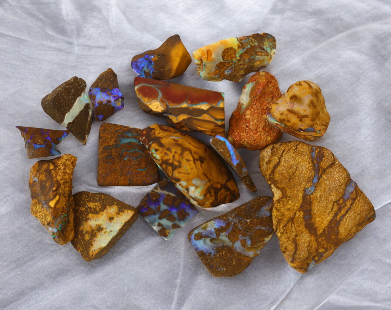 AUSTRALIA: Matrix Boulder Opal Rough Lot, 27g, 1-2.5 cm (Images Taken Wet): Stunning lot of natural Australian matrix boulder opal rough, these specimens showcase a vibrant interplay of opalized veins and swirls embedded in rich ironstone, displaying flashes of electric blues