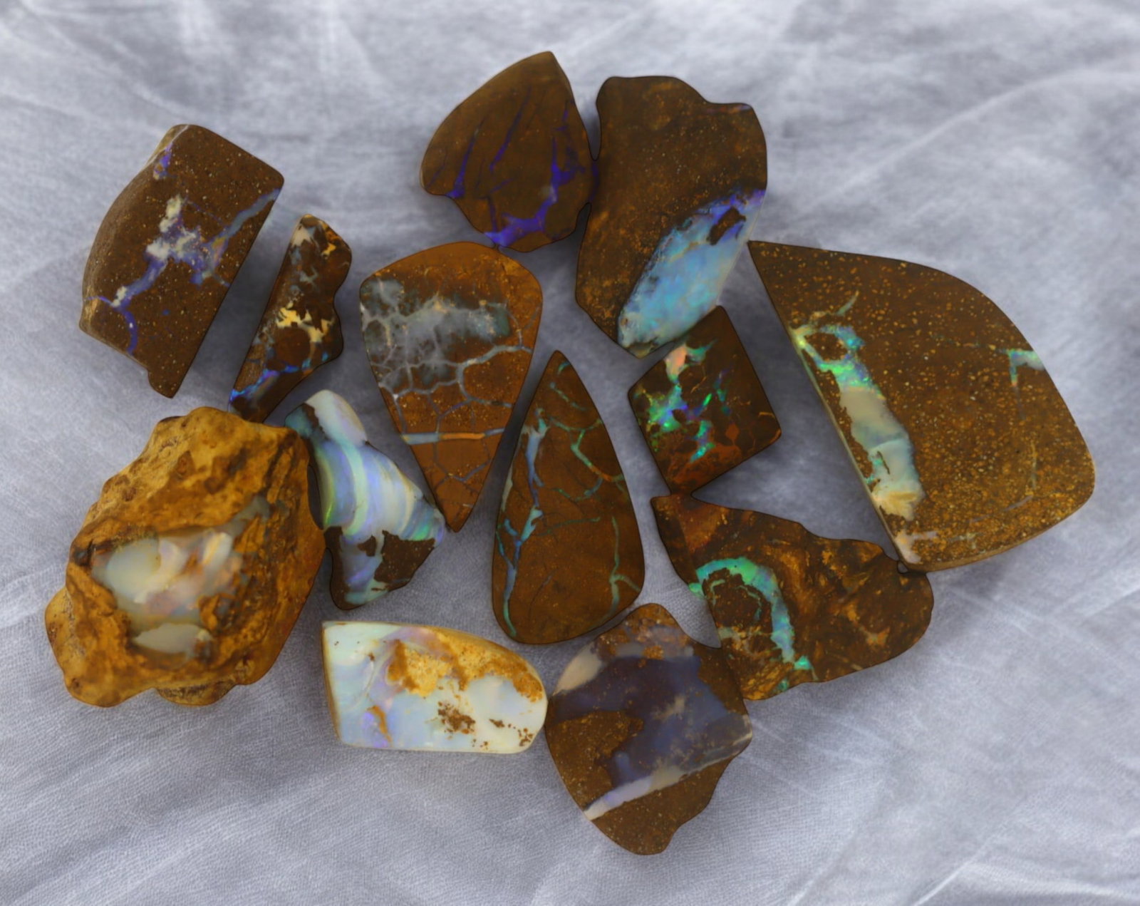 AUSTRALIA: Matrix Boulder Opal Rough Lot, 18g, 0.8-2.5 cm (Images Taken Wet): Stunning lot of natural Australian matrix boulder opal rough, these specimens showcase a vibrant interplay of opalized veins and swirls embedded in rich ironstone, displaying flashes of electric blues