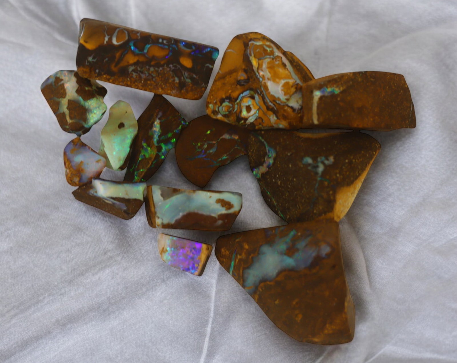 AUSTRALIA: Matrix Boulder Opal Rough Lot, 19g, 0.7-1.8 cm (Images Taken Wet): Stunning lot of natural Australian matrix boulder opal rough, these specimens showcase a vibrant interplay of opalized veins and swirls embedded in rich ironstone, displaying flashes of electric blues