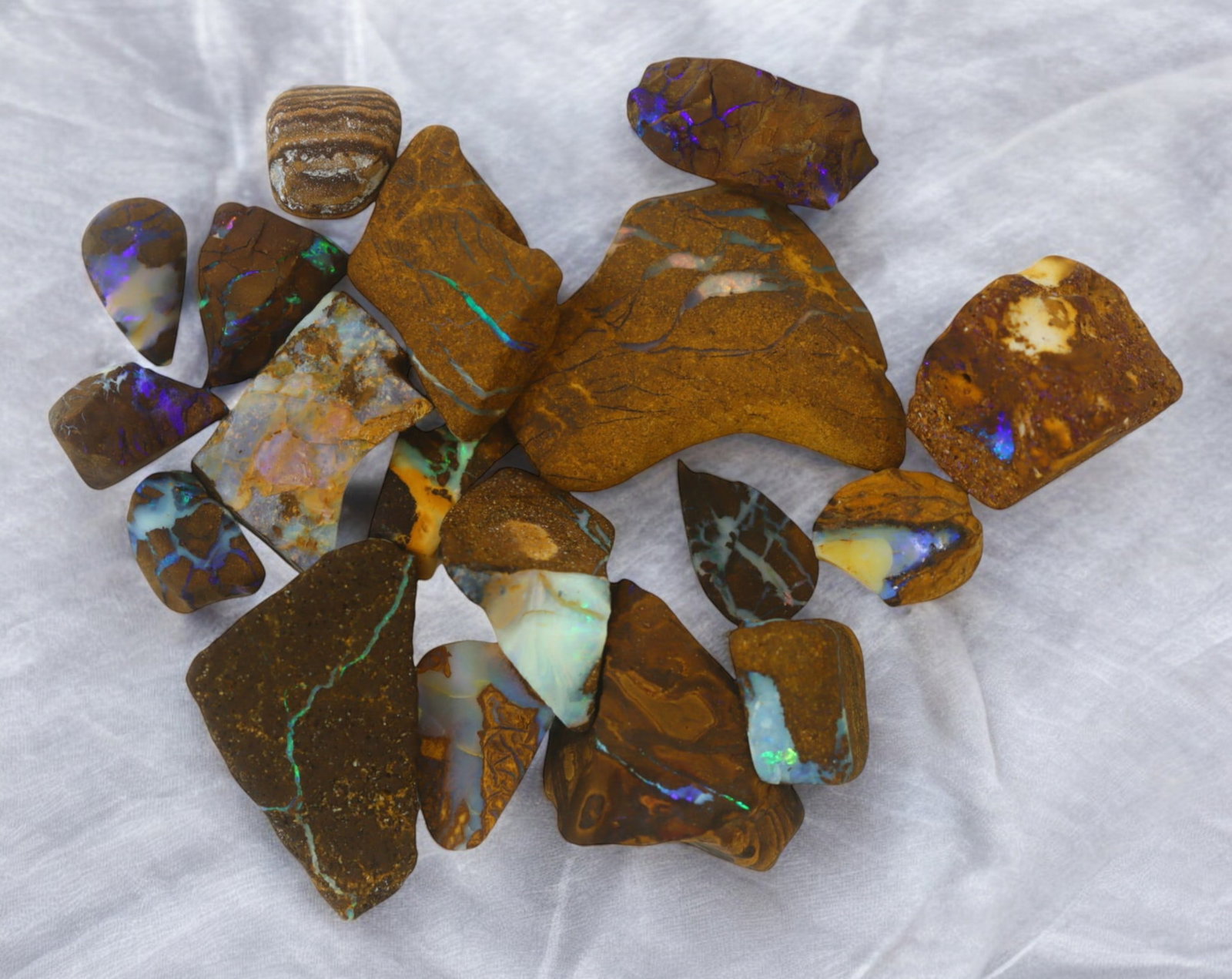 AUSTRALIA: Matrix Boulder Opal Rough Lot, 27g, 1-2 cm (Images Taken Wet): Stunning lot of natural Australian matrix boulder opal rough, these specimens showcase a vibrant interplay of opalized veins and swirls embedded in rich ironstone, displaying flashes of electric blues