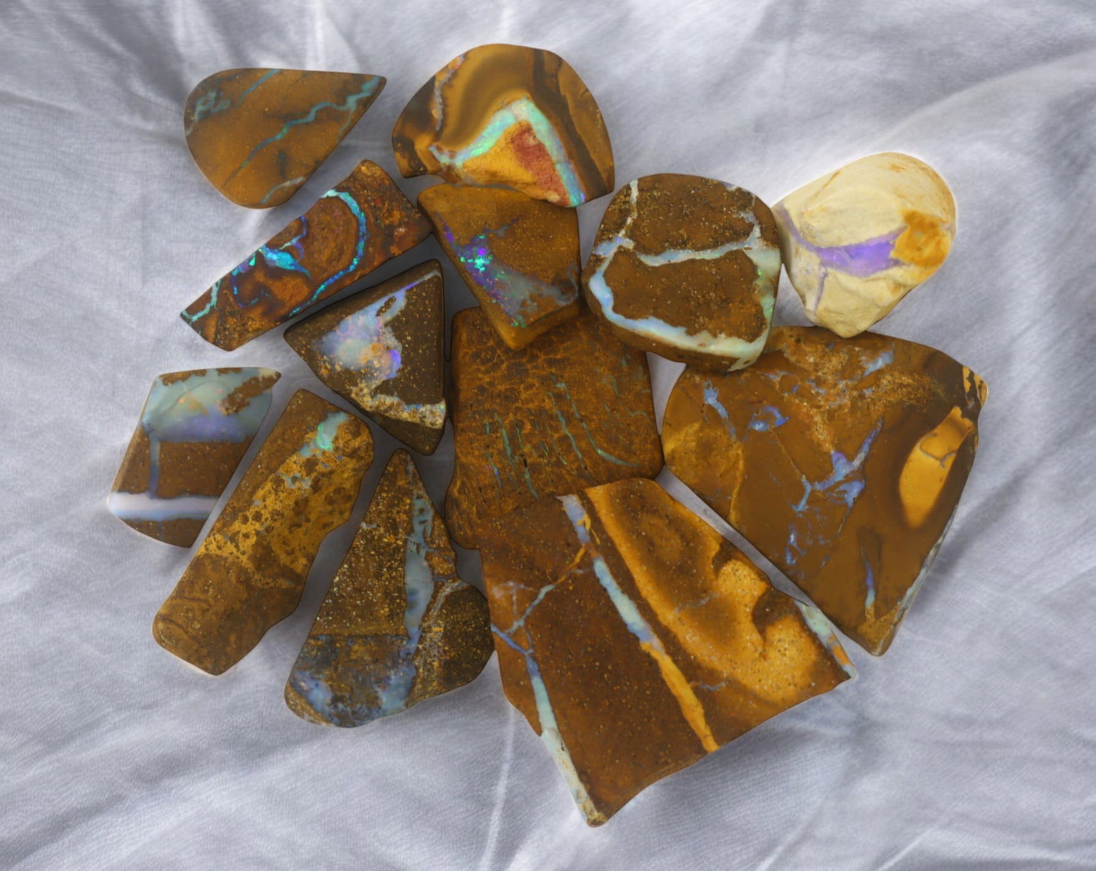 AUSTRALIA: Matrix Boulder Opal Rough Lot, 29g, 1-2.2 cm (Images Taken Wet): Stunning lot of natural Australian matrix boulder opal rough, these specimens showcase a vibrant interplay of opalized veins and swirls embedded in rich ironstone, displaying flashes of electric blues