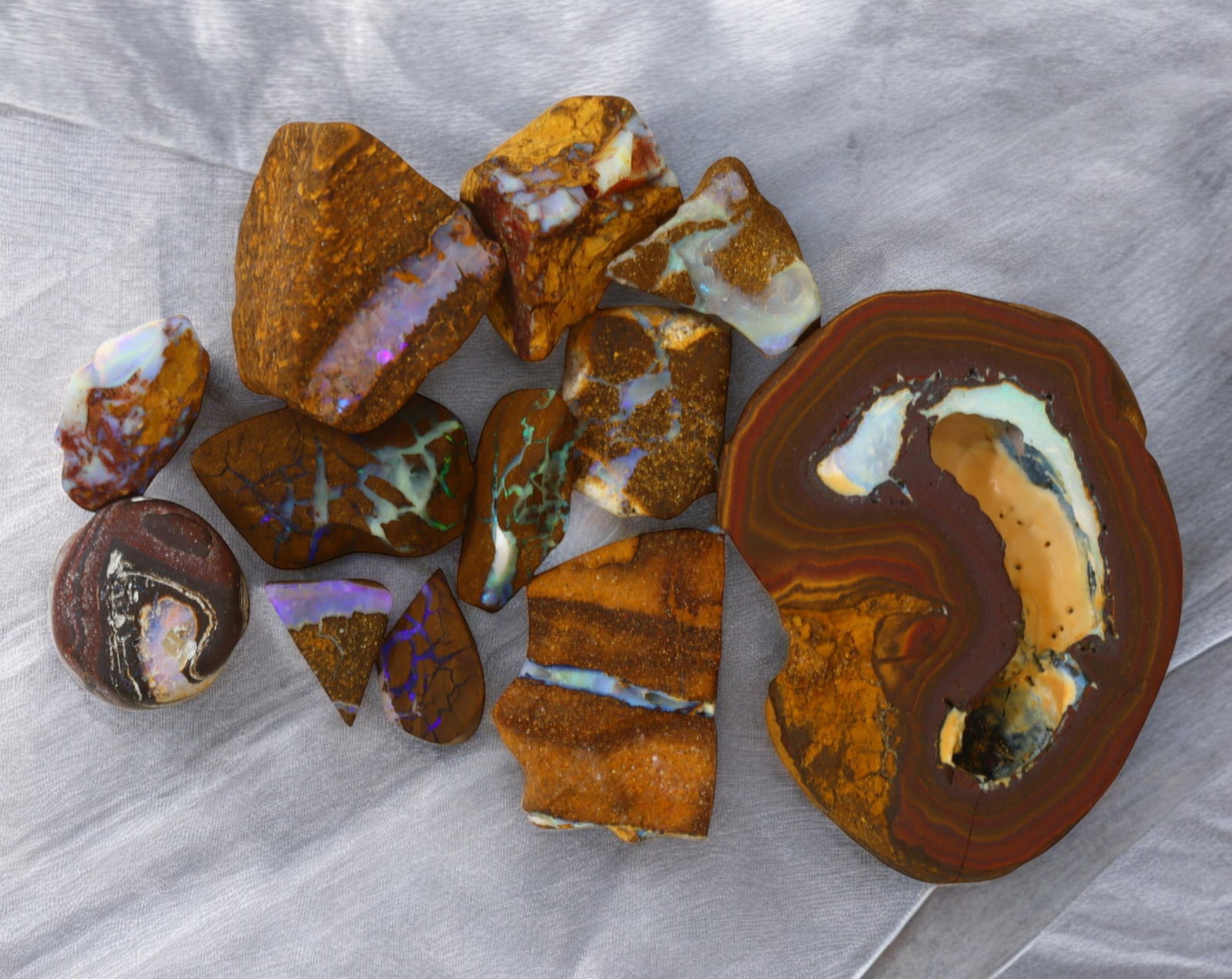 AUSTRALIA: Matrix Boulder Opal Rough Lot, 41g, 1-3.9 cm (Images Taken Wet): Stunning lot of natural Australian matrix boulder opal rough, these specimens showcase a vibrant interplay of opalized veins and swirls embedded in rich ironstone, displaying flashes of electric blues