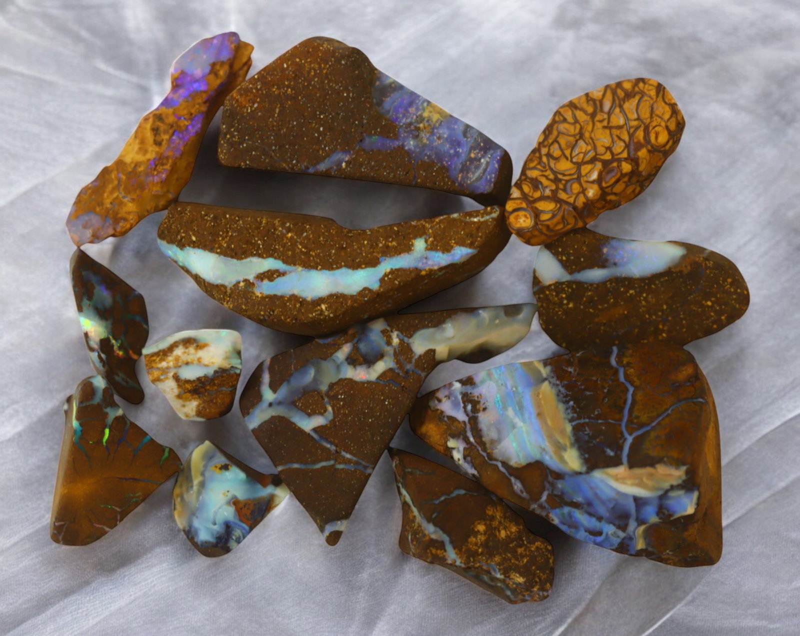 AUSTRALIA: Matrix Boulder Opal Rough Lot, 28g, 0.4-2.7 cm (Images Taken Wet): Stunning lot of natural Australian matrix boulder opal rough, these specimens showcase a vibrant interplay of opalized veins and swirls embedded in rich ironstone, displaying flashes of electric blues