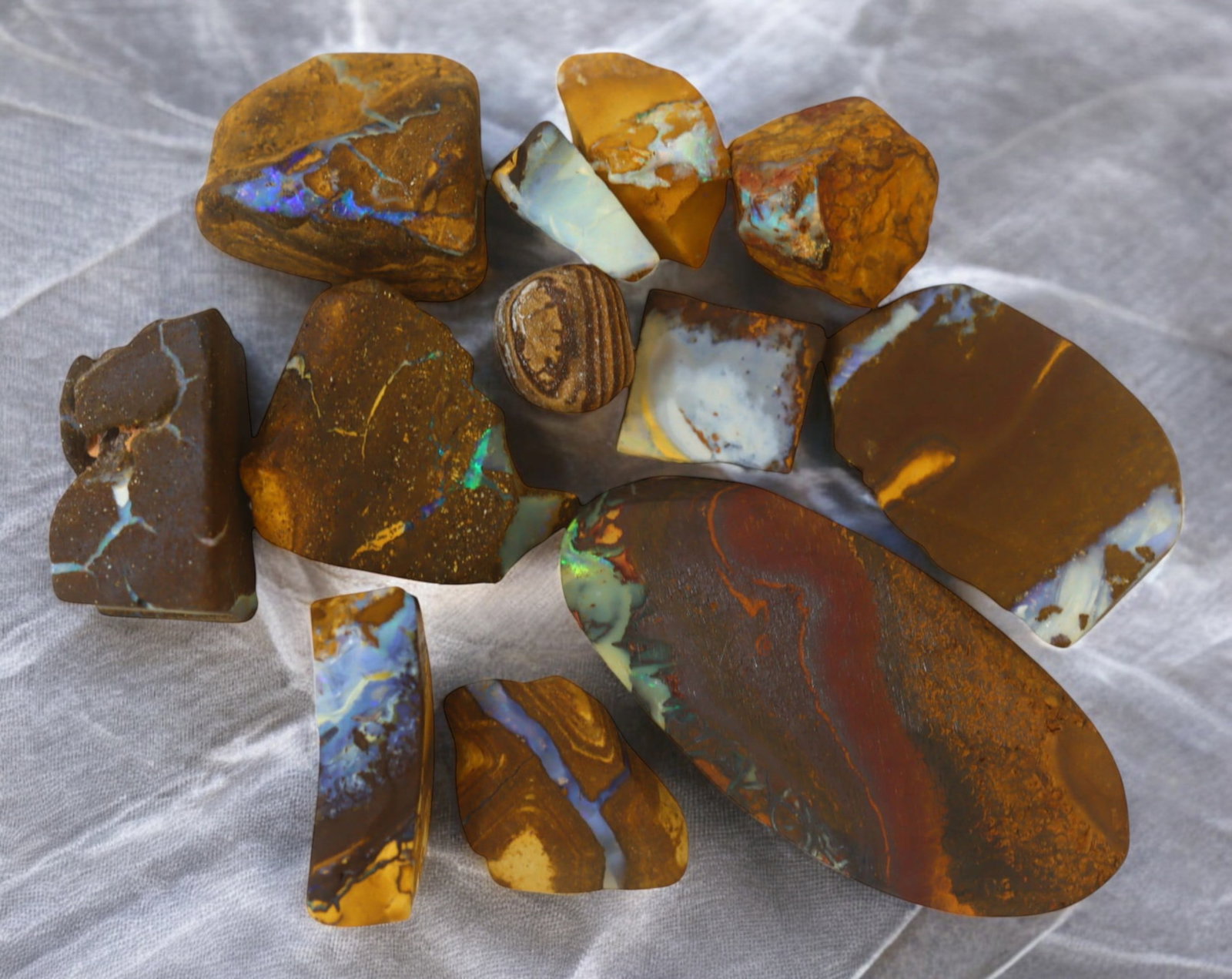 AUSTRALIA: Matrix Boulder Opal Rough Lot, 33g, 1-3.9 cm (Images Taken Wet): Stunning lot of natural Australian matrix boulder opal rough, these specimens showcase a vibrant interplay of opalized veins and swirls embedded in rich ironstone, displaying flashes of electric blues