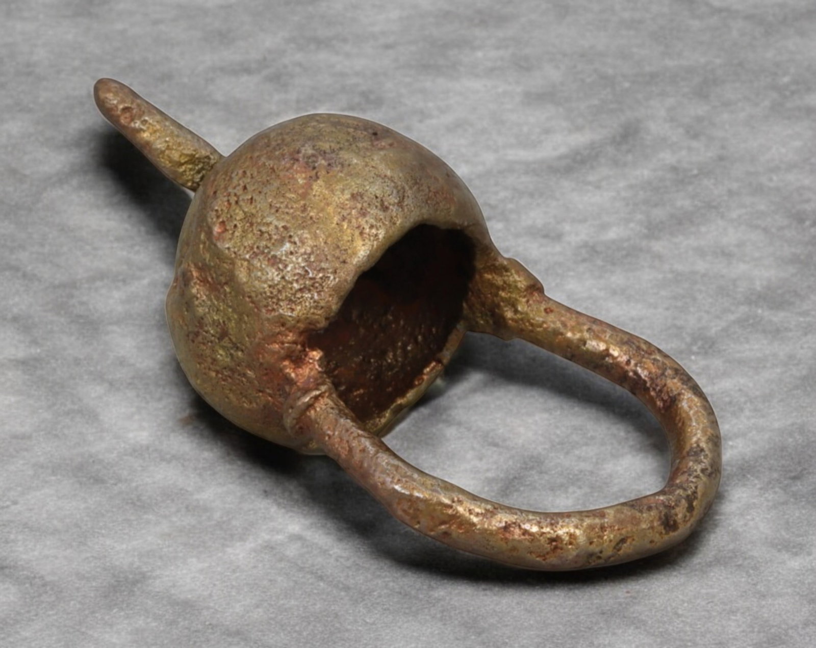 AFRICAN TRIBAL: Currency Ring - Rough-Cast Bronze with Bell-Like Dome, ca. 19th Century: This 5.5 cm bronze ring embodies the raw, tactile power of West African metalwork, cast in a bulbous bell-like form with a prominent suspension loop and perforations that may have once aided stringing