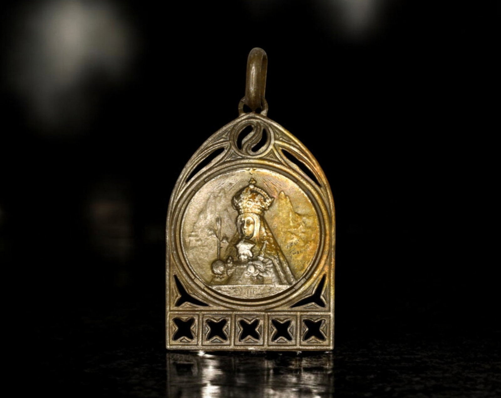 SPAIN: Nuestra Senora de Montserrat Devotional Medal - Brass, Gothic Arch Design: A Spanish devotional medal, struck in brass, measuring 1.9x3.1cm and weighing 4.6g, dedicated to Nuestra Senora de Montserrat. The obverse presents an image of the Black Madonna, crowned and enthroned