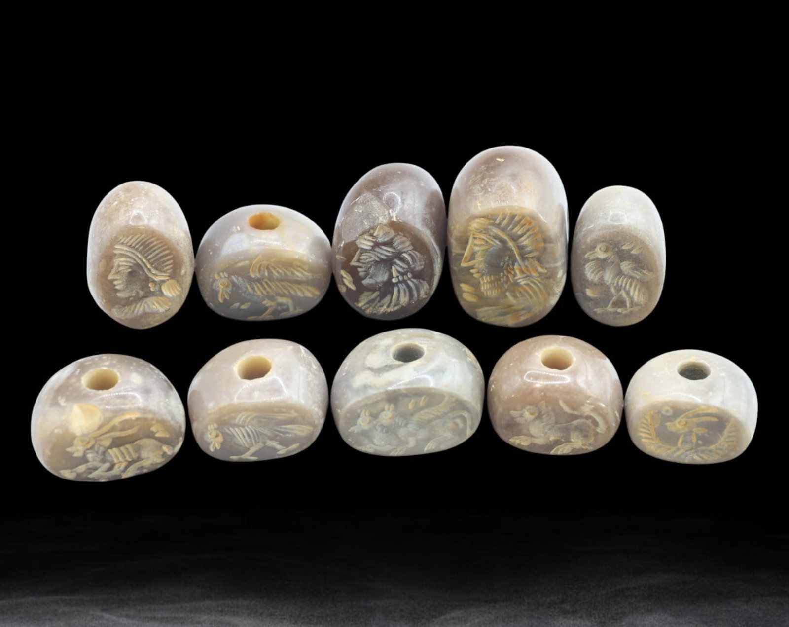 MIDDLE EAST / SOUTH PACIFIC: Intaglio Agate Beads - Set of 10, 19th-20th Century: A fine collection of ten antique intaglio-carved agate beads, averaging 2cm in size and weighing a total of 118g. These expertly engraved beads feature a variety of motifs, including warrior profiles,