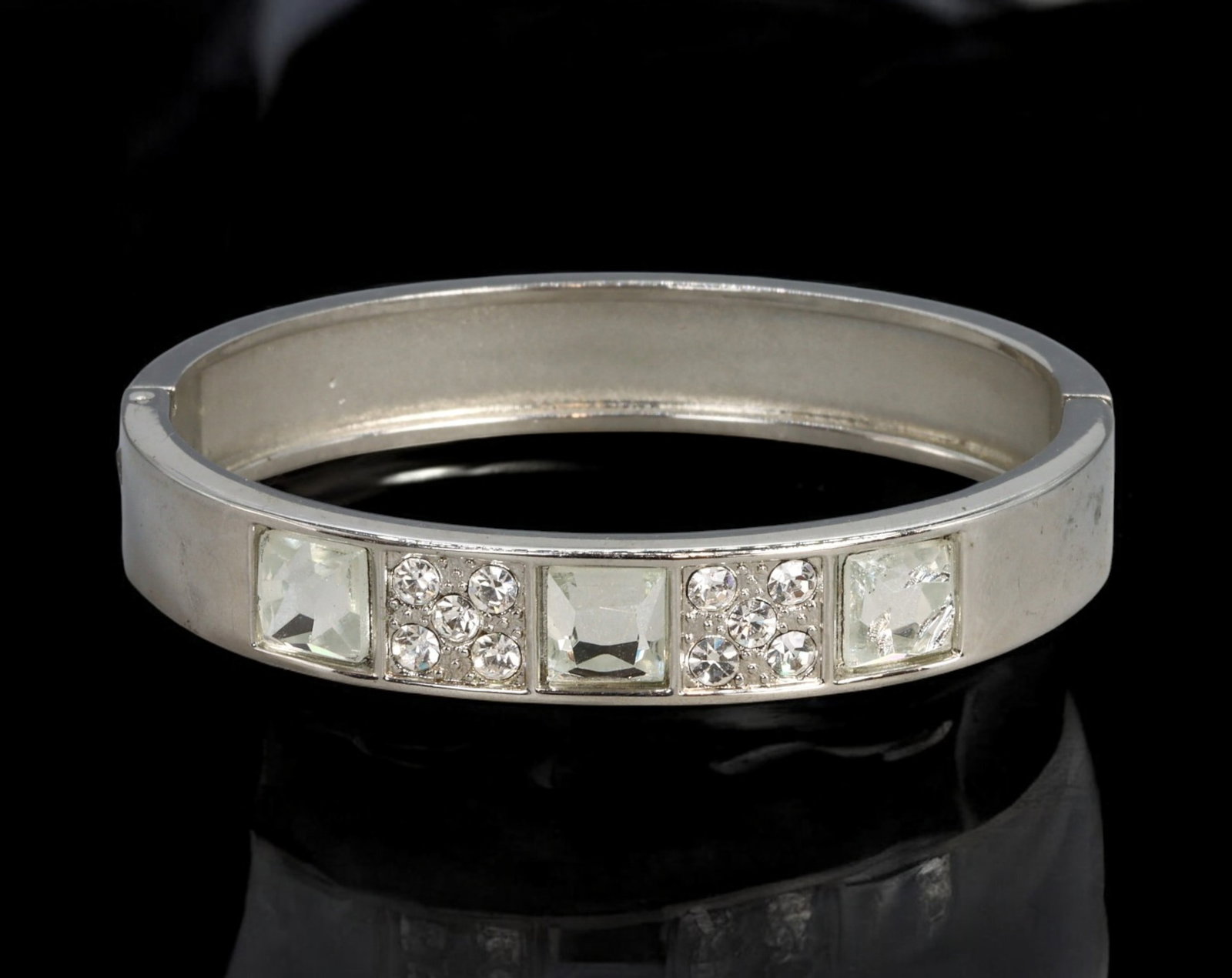 RETRO MODERN: Bangle - Silver-Tone with Square and Clustered Clear Stones, 6.7cm (36g): A sleek Retro Modern bangle in polished silver-tone metal featuring alternating panels of square-cut and clustered round clear stones. The minimalist structure is offset by a rhythmic arrangement of f