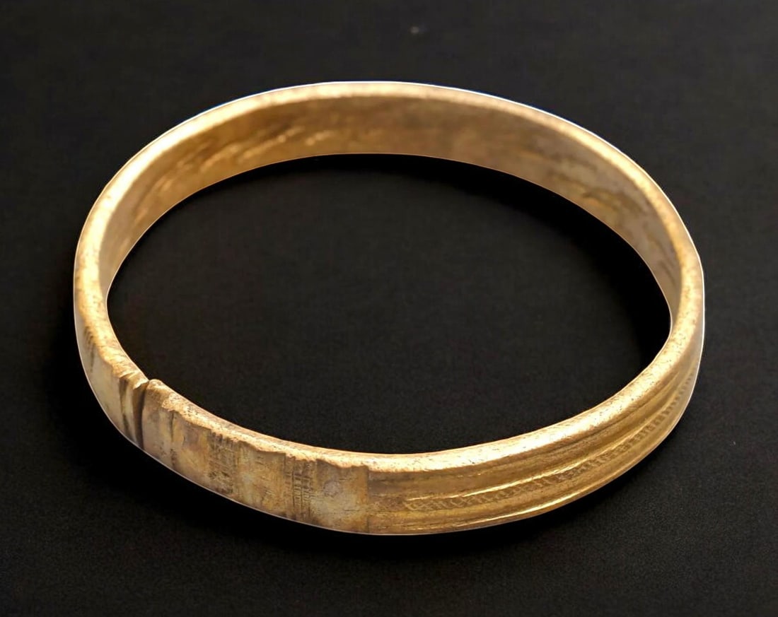 AFRICAN TRADE: Flat-Edged Bangle - Gilt Brass with Incised Motifs, West Africa, 8 cm Diameter: AFRICAN TRADE: Flat-Edged Bangle - Gilt Brass with Incised Motifs, West Africa, 8 cm DiameterUnderstated yet resonant with heritage, this West African gilt bangle showcases traditional form with subtl